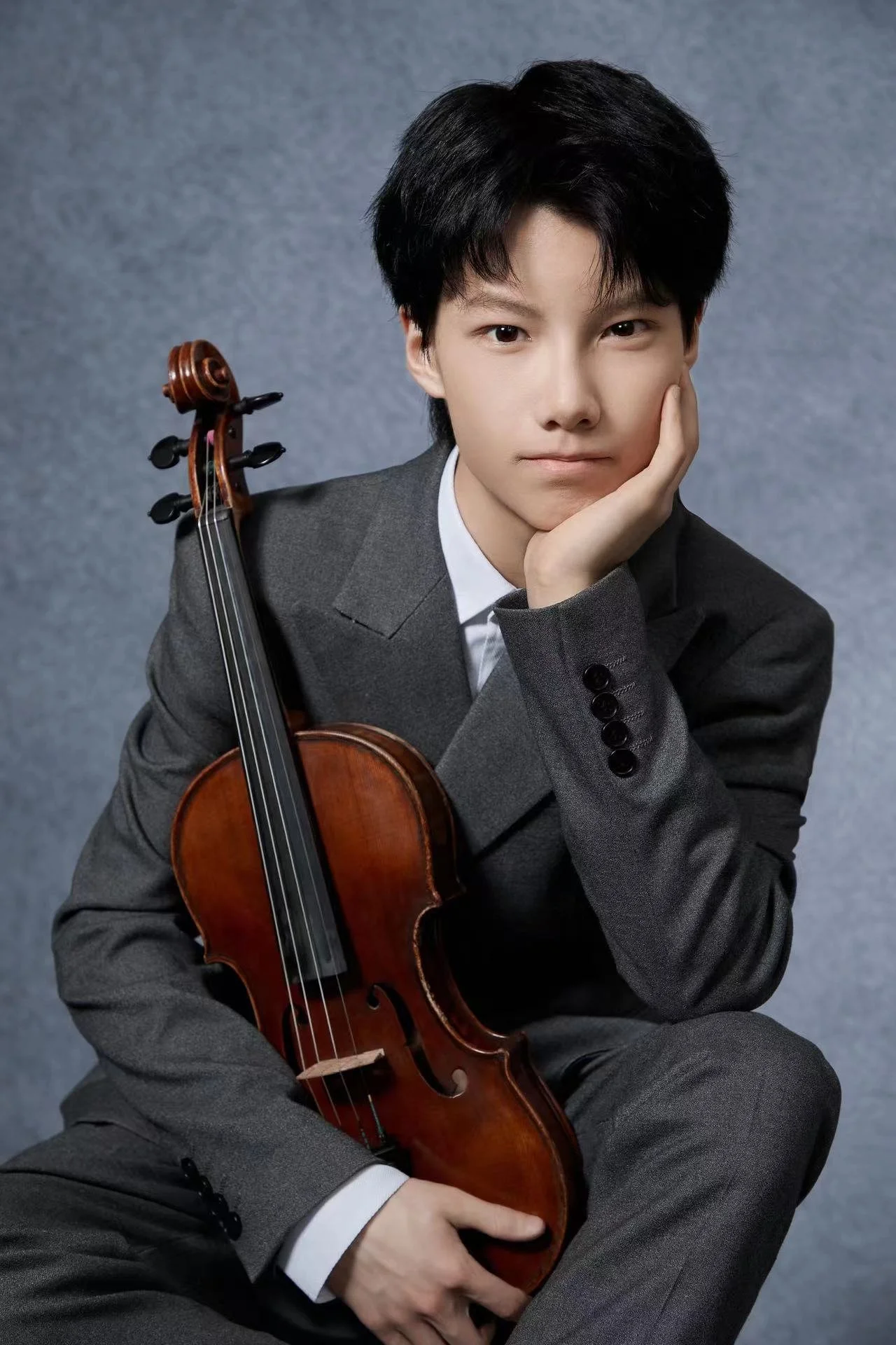 A young violinist in formal performance attire, reflecting long-term musical development and UK education planning.