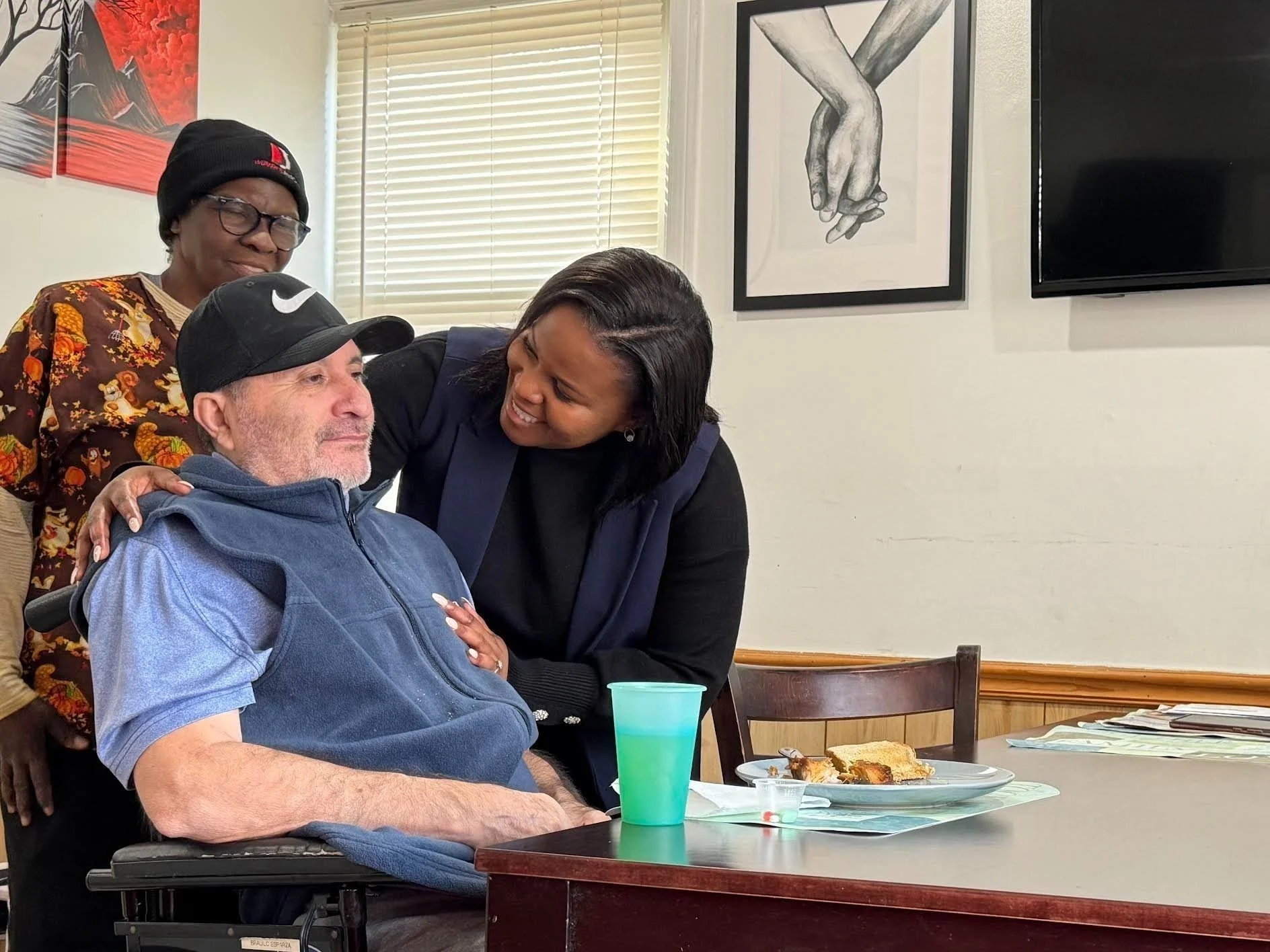 Quincy Bareebe engaging with an older adult in a wheelchair, underscoring her pledge to protect Medicare, VA benefits, and disability access in Maryland.
