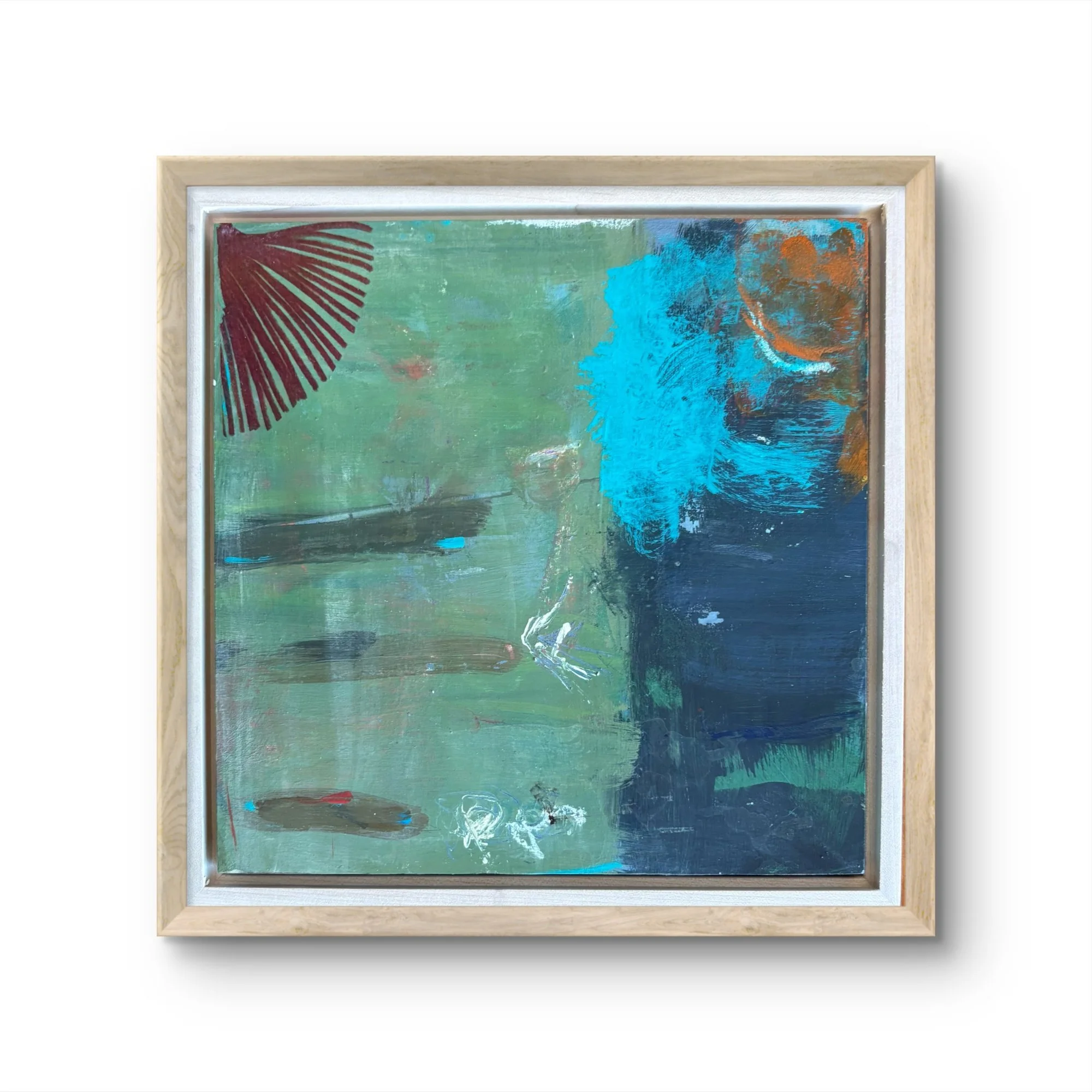 Abstract mixed media painting with a green background, a splash of bright blue, and a fan-like maroon shape in a light wood frame.