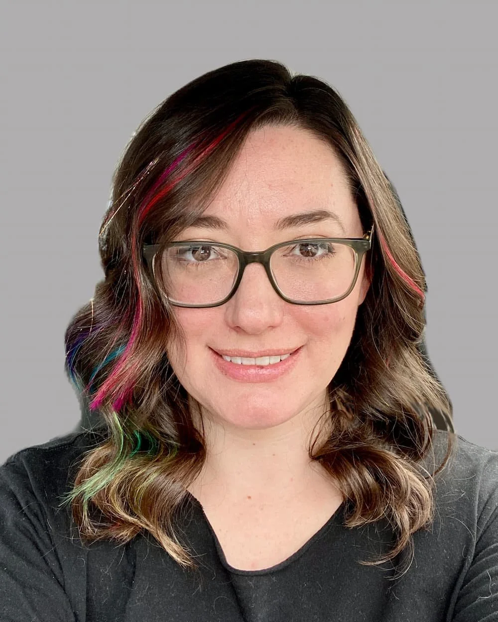 Headshot of a woman with brown hair and glasses, with a grey background