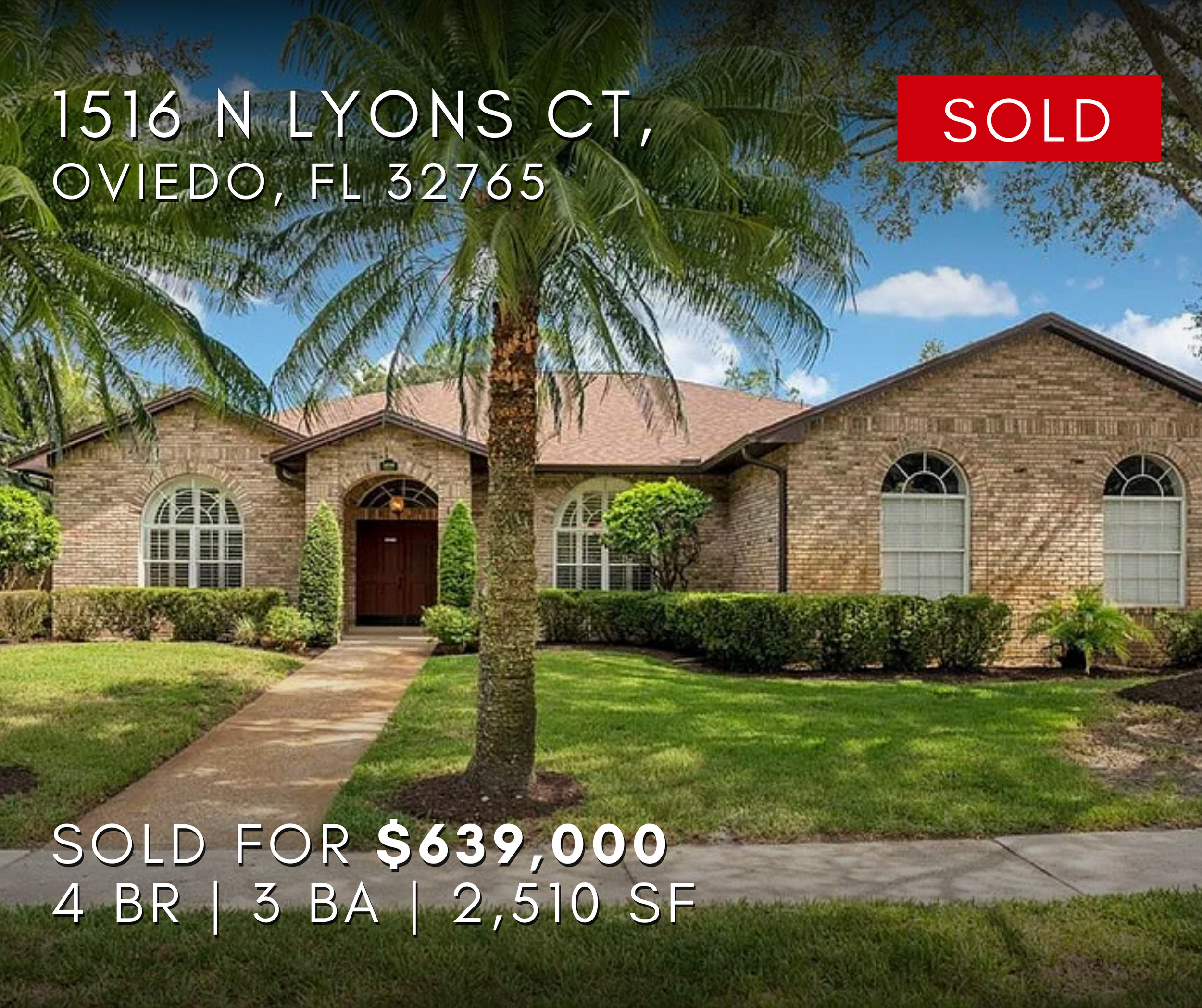 1516 North Lyons Court, Oviedo, Florida 32765 A brick house with arched windows and a front door, surrounded by green bushes and a palm tree, with a blue sky and clouds overhead.