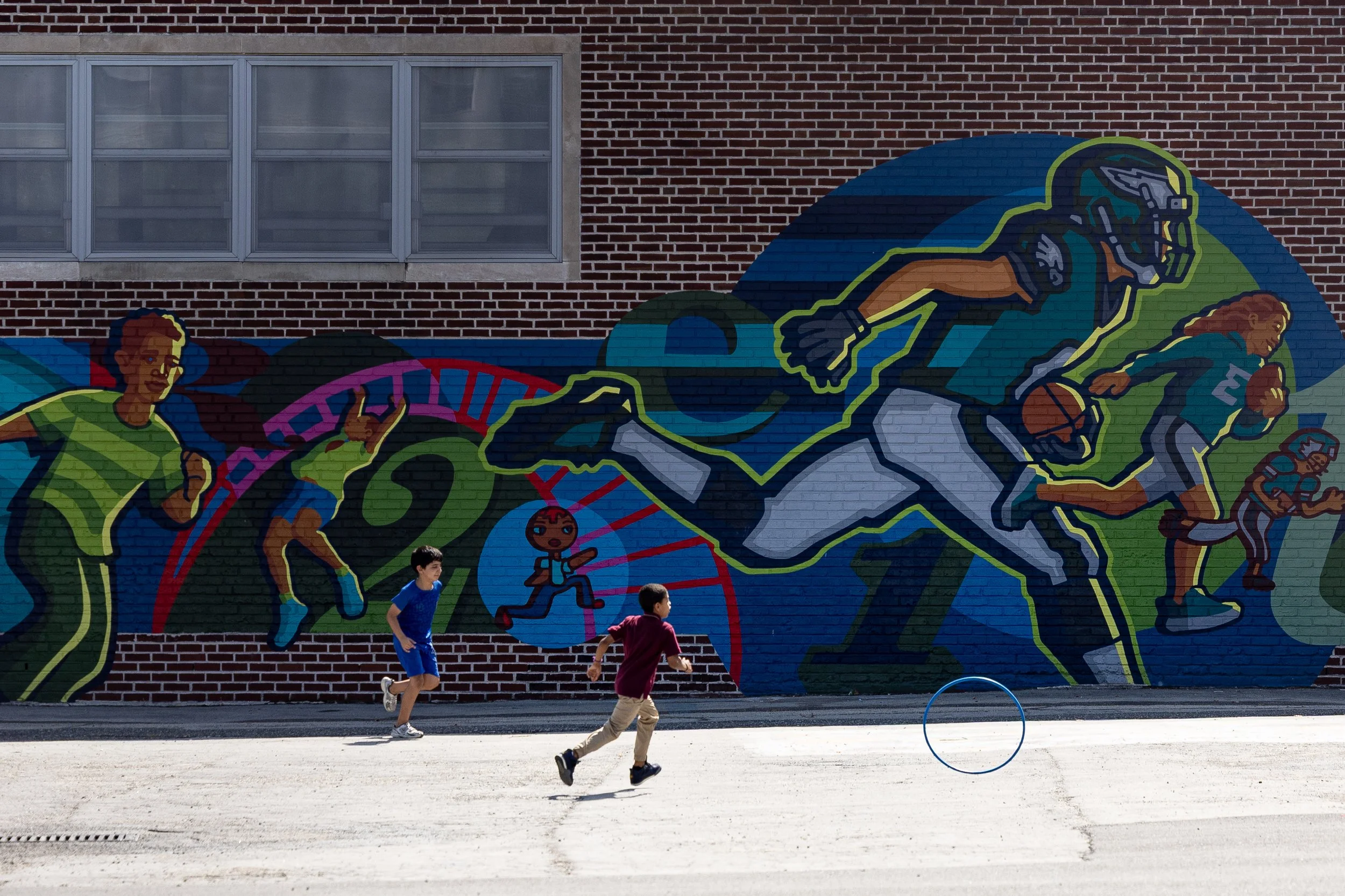 Girard Elementary students chase after a moving hula hoop during the Sixers Literacy pep rally in front of the school’s Eagles mural in South Philadelphia on Thursday, Sept. 10, 2026. 