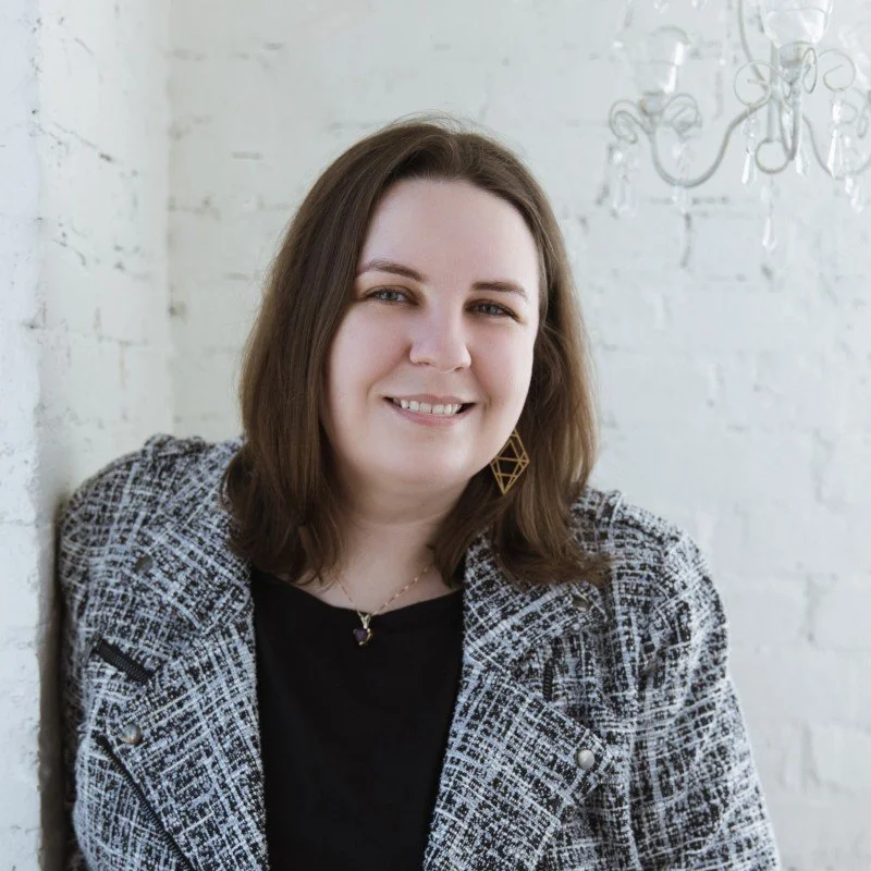 Headshot of DaiLynn wearing a black and white tweed jacket
