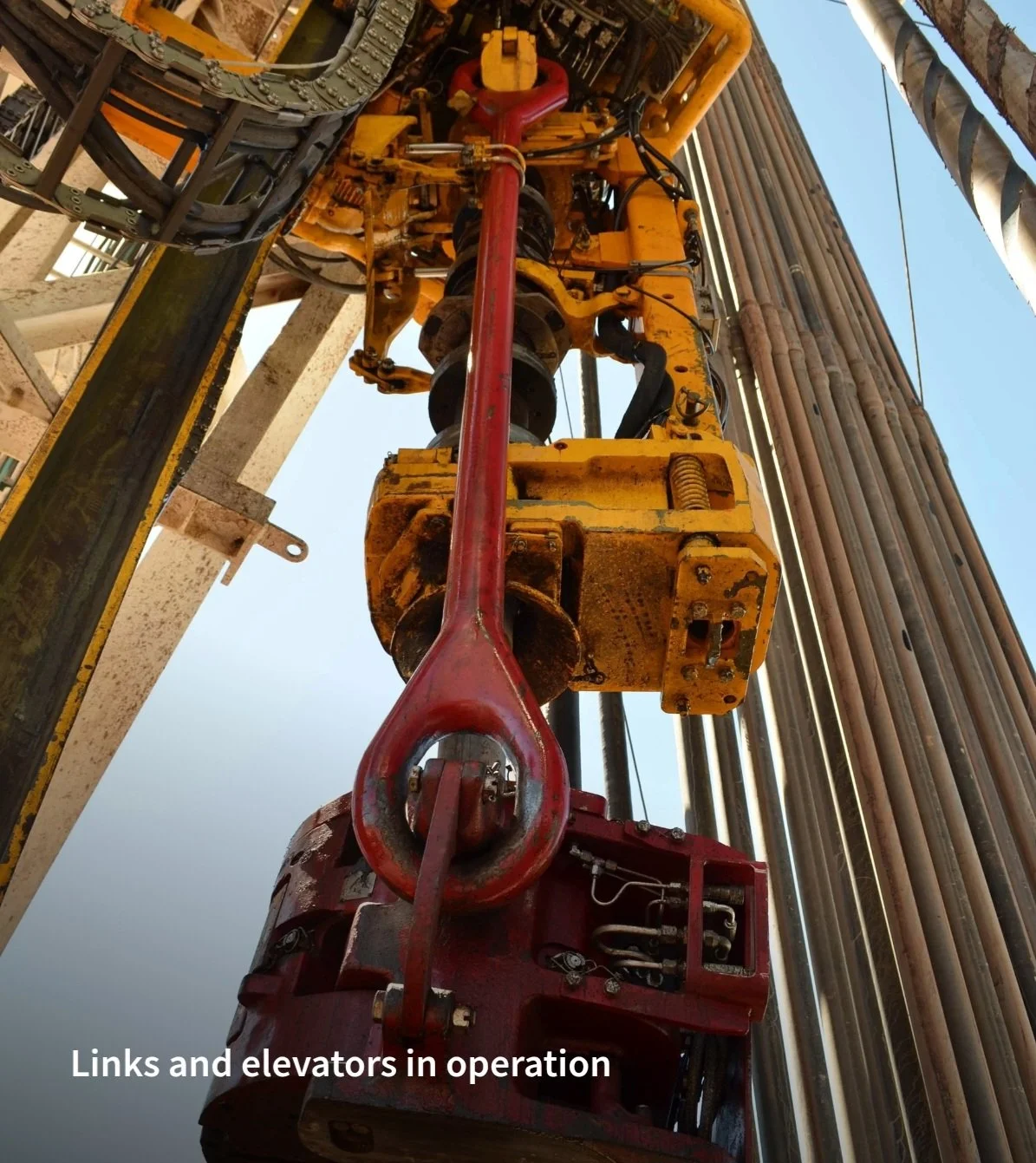 Estructura de perforación con enlaces y elevadores en operación en un sitio de petróleo o minería.
