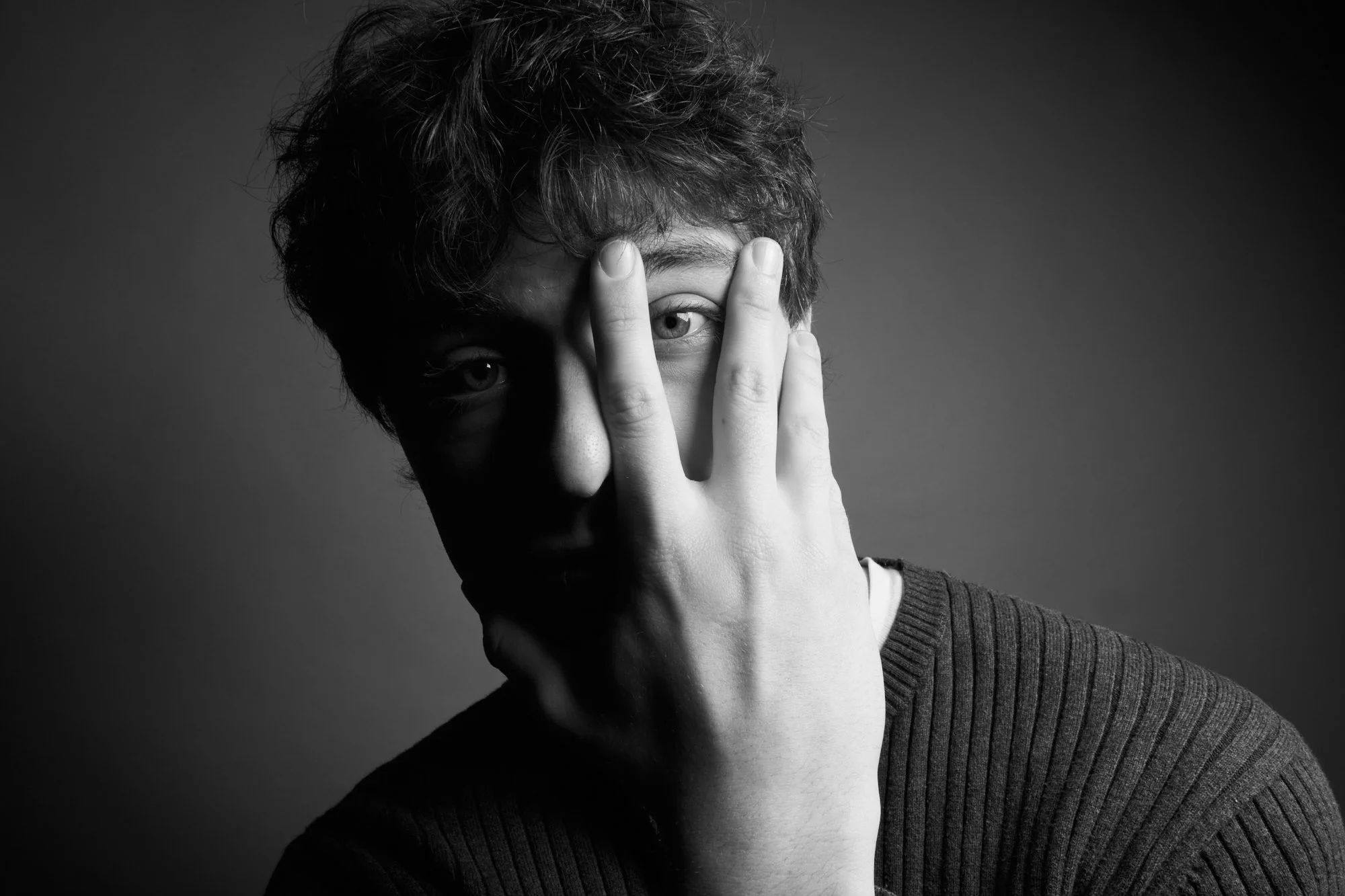 Black and white portrait with hand partially covering one eye, studio portrait in Concord Massachusetts