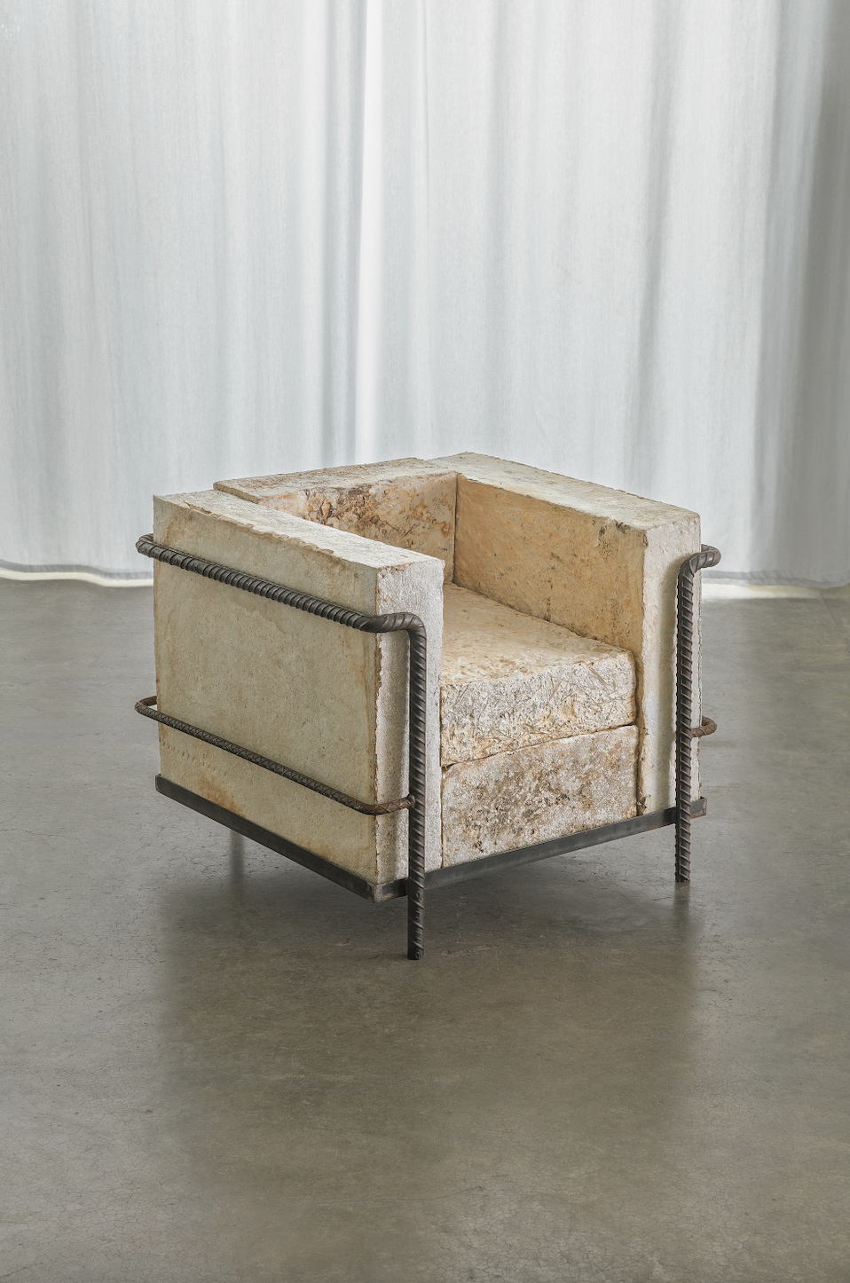 Mycelium armchair by Monterr Lab constructed from biofabricated mycelium blocks and an exposed steel rebar frame.