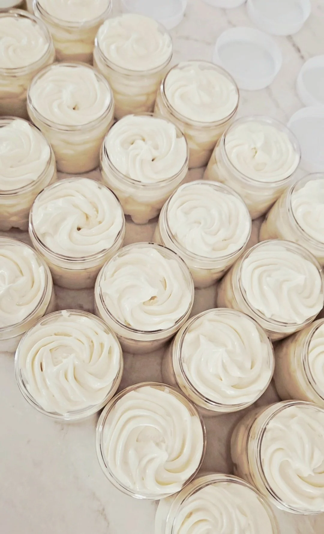 Multiple small jars filled with creamy body butter