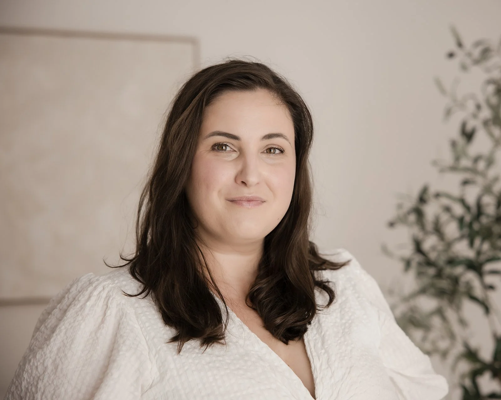 A young man with a beard and mustache wearing a black baseball cap backwards and a gray T-shirt with a pink Superman logo, standing outdoors against a blue sky background.
