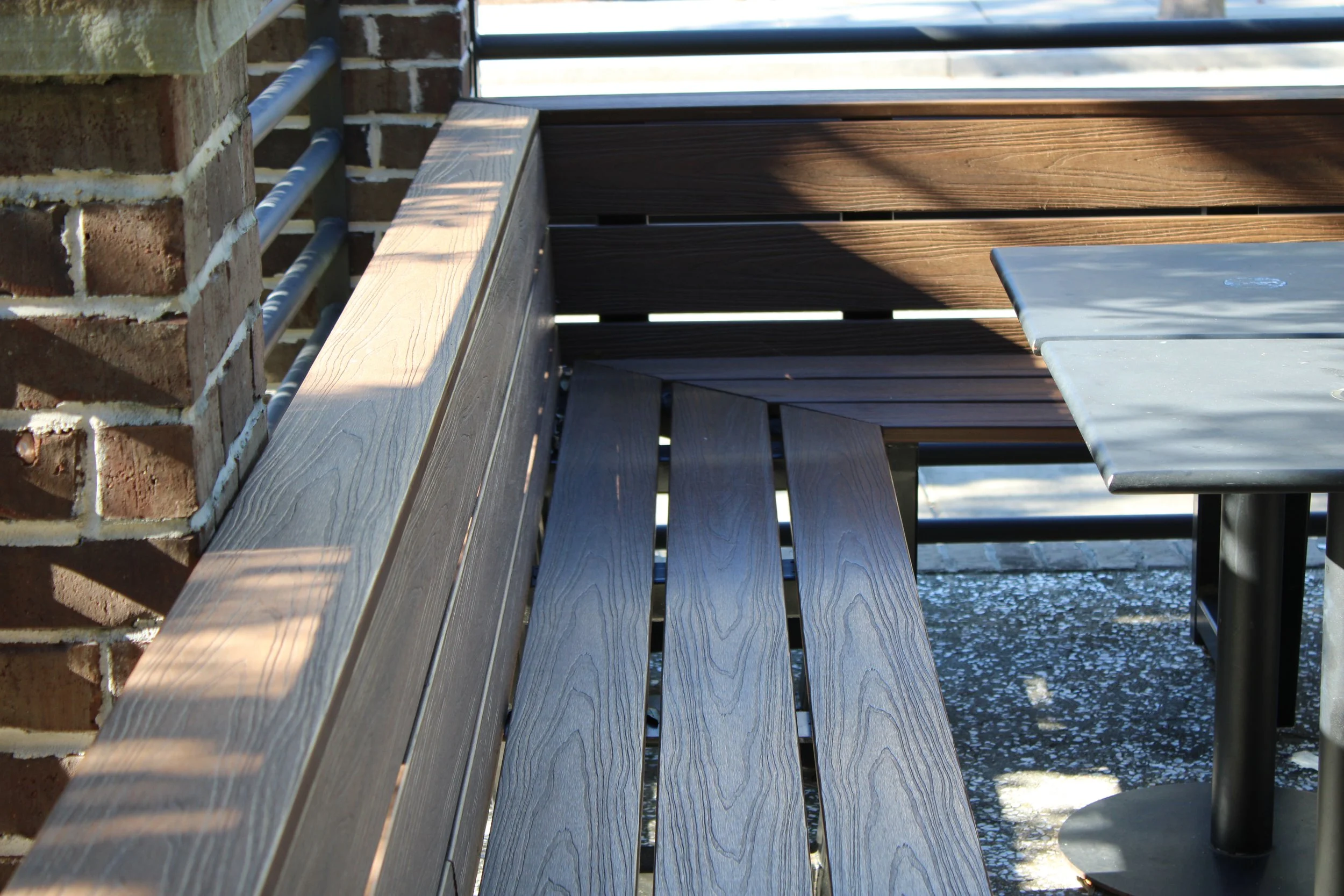 Close-up of a wooden bench with horizontal planks and a concrete and metal structure.