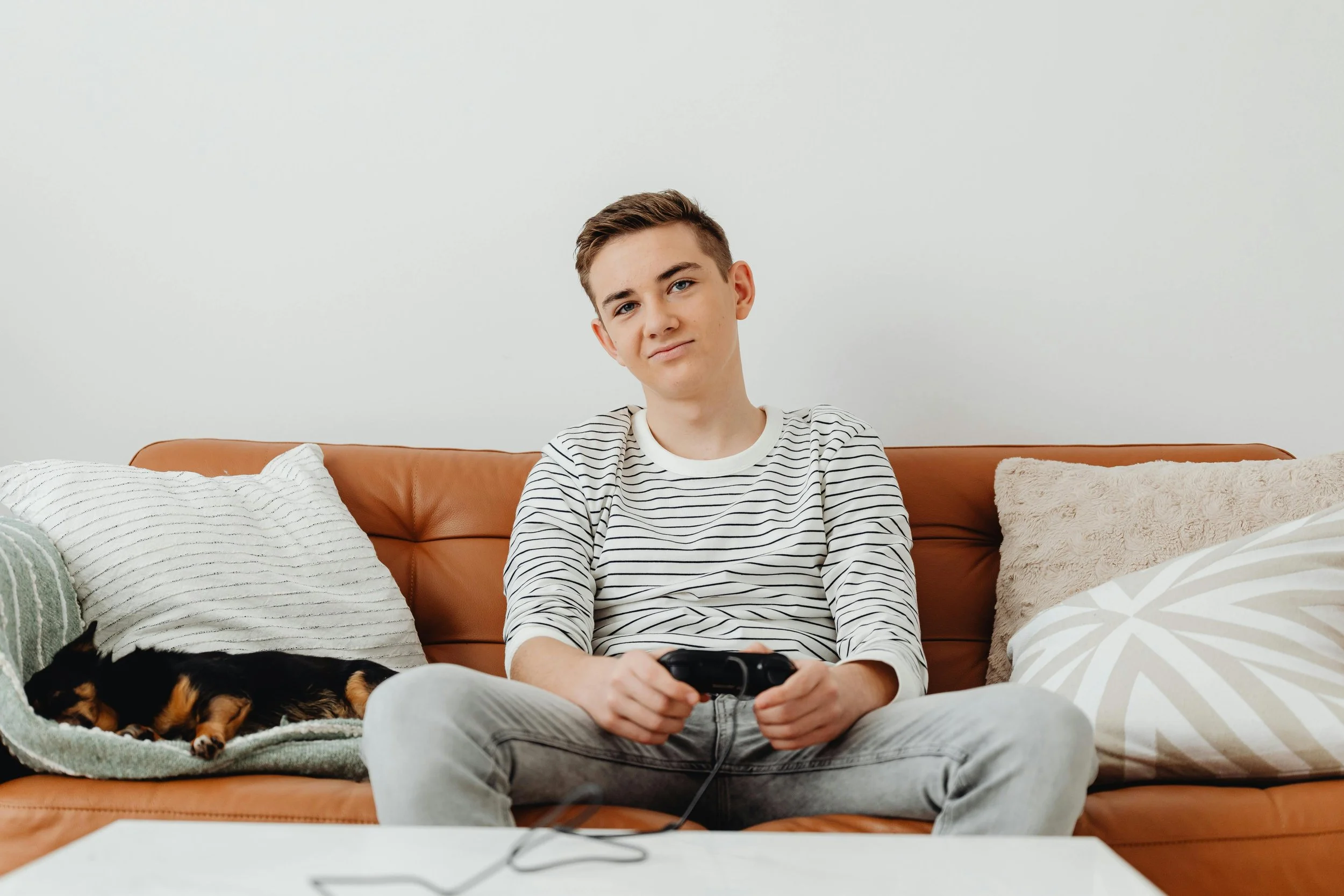 In the basement entertainment area, a teenage boy plays video games