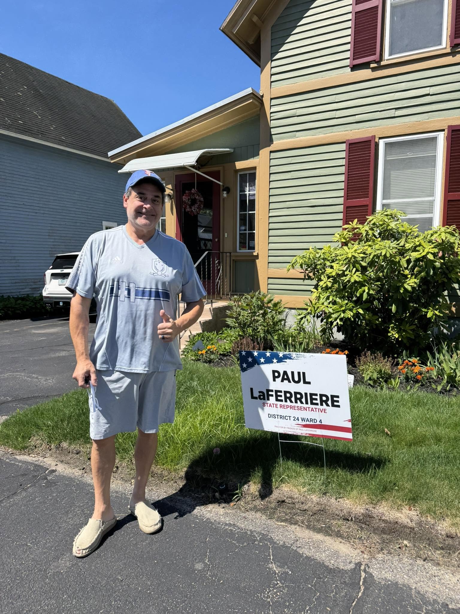 Campaign supporter in front of his house with a sign for Paul LaFerriere, State Representative, District 24, Ward 4.