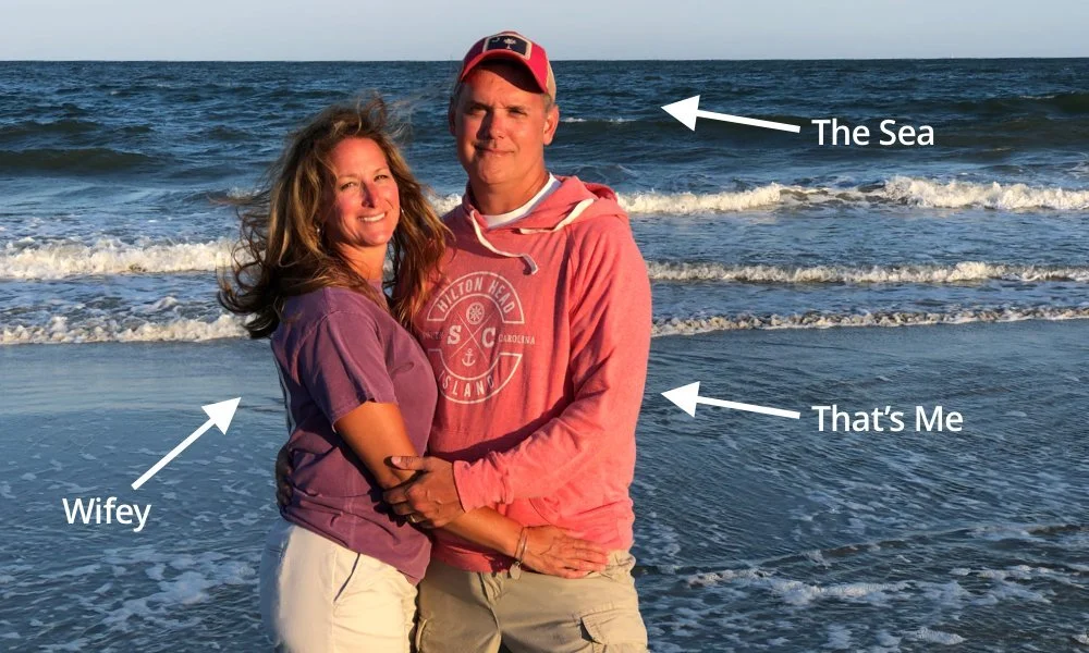 A couple standing on a beach near the ocean, with waves in the background, smiling at the camera. The woman is labeled 'Wifey,' and the man is labeled 'That's Me.' The ocean is labeled 'The Sea.'
