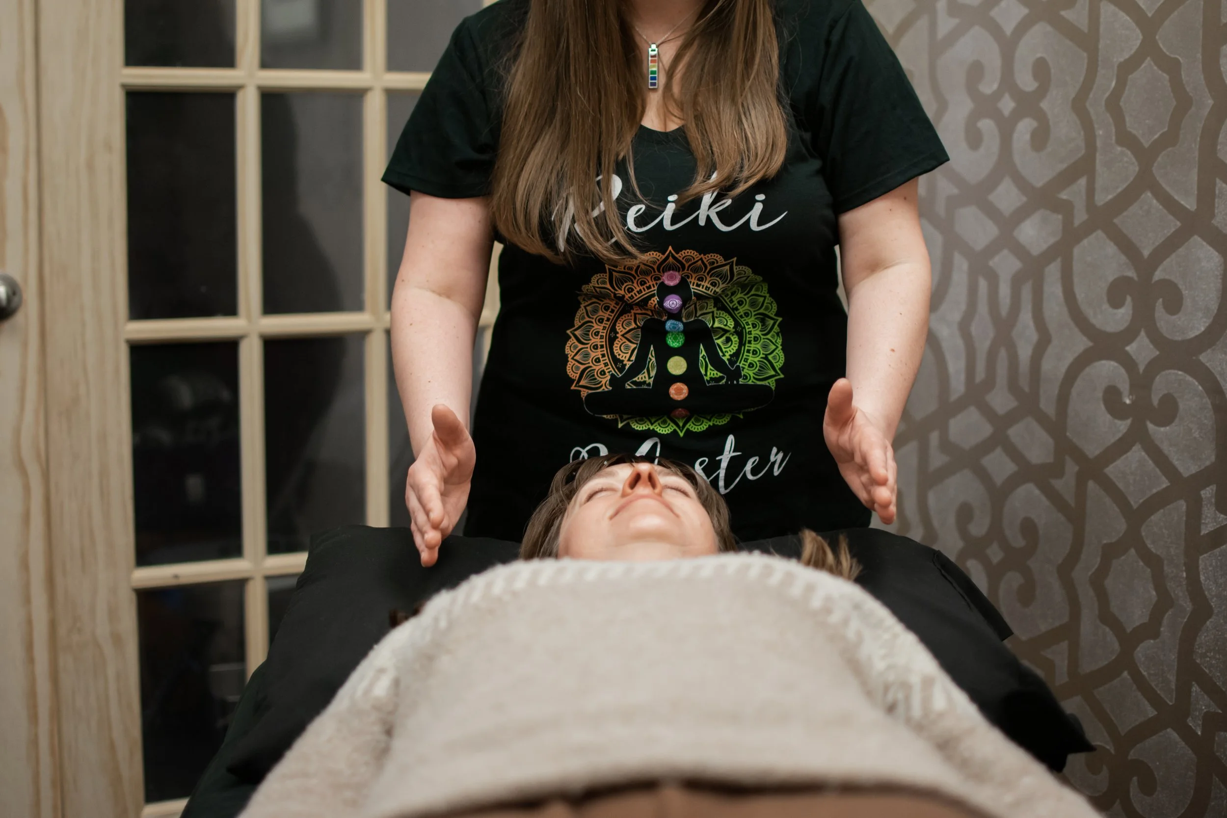 Rachele Rose giving an energy healing session to a client at Namaste Yoga in Royal Oak