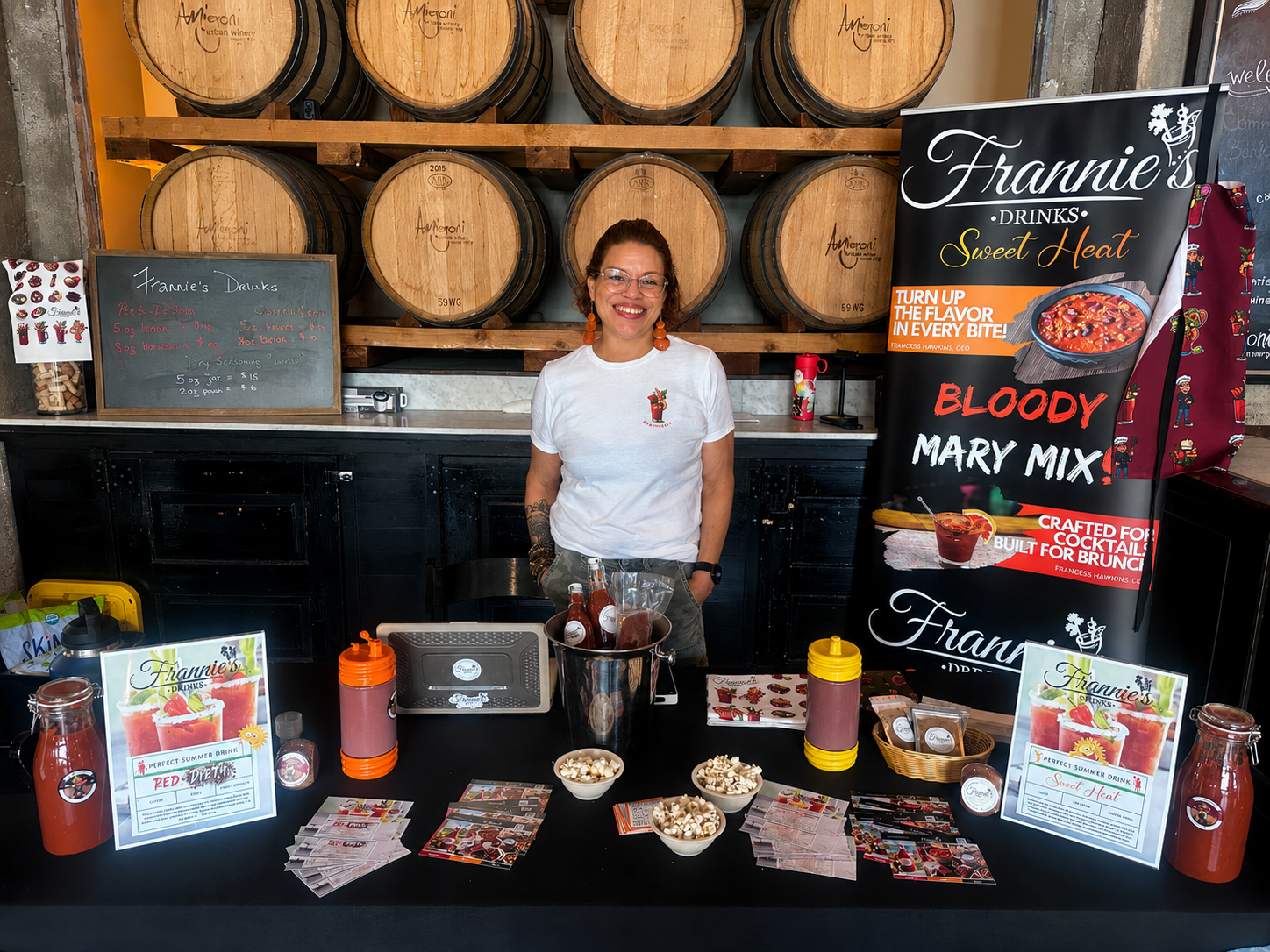Francess Hawkins at Frannie’s Drinks pop up booth with Bloody Mary mix displays and event setup.