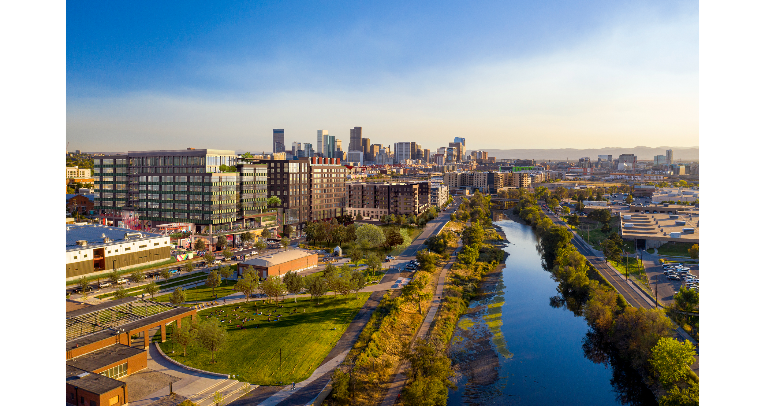 Aerial view of downtown Los Angeles with a river running through a park in the foreground during sunset.