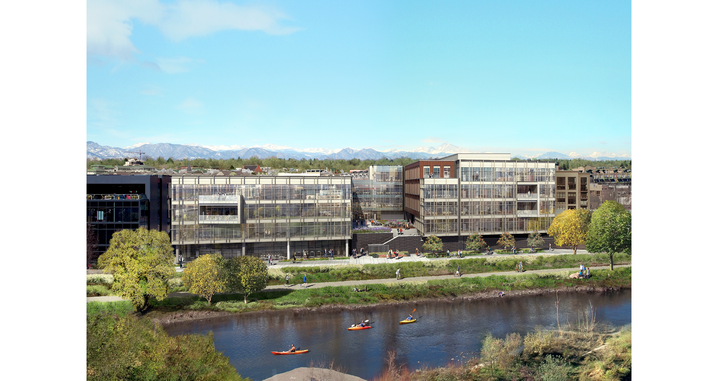 Modern glass buildings along a river with people kayaking and walking on the grassy riverbank, mountains in the background on a clear day.