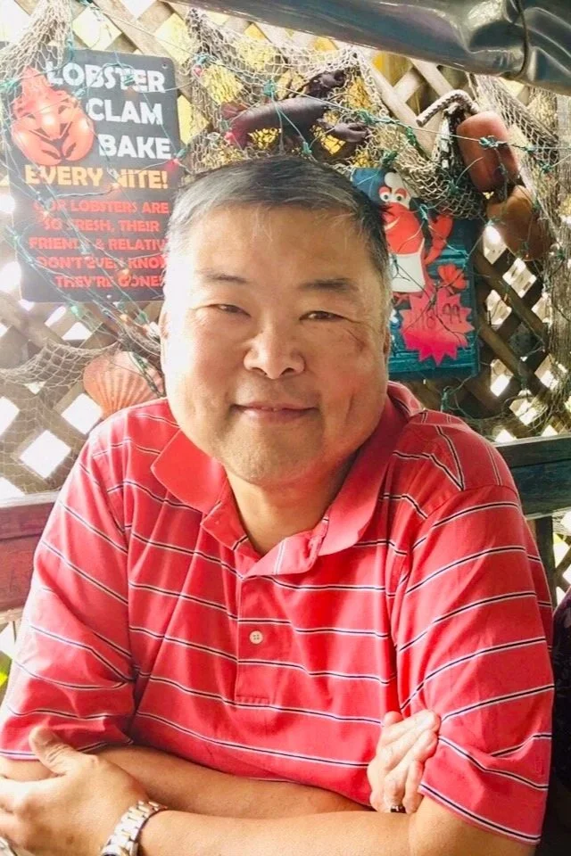 Alice Chen's father, a Chinese man wearing a red striped shirt, whose story shaped the philosophy behind The Unlearning Studio