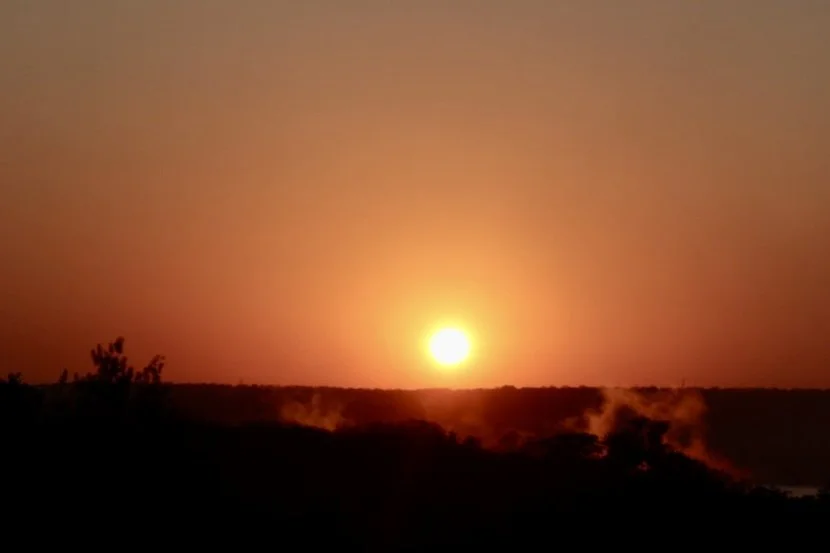 A breathtaking sunrise over Victoria Falls, representing the transformative power of travel, immersion and the awe that opens us to new ways of being