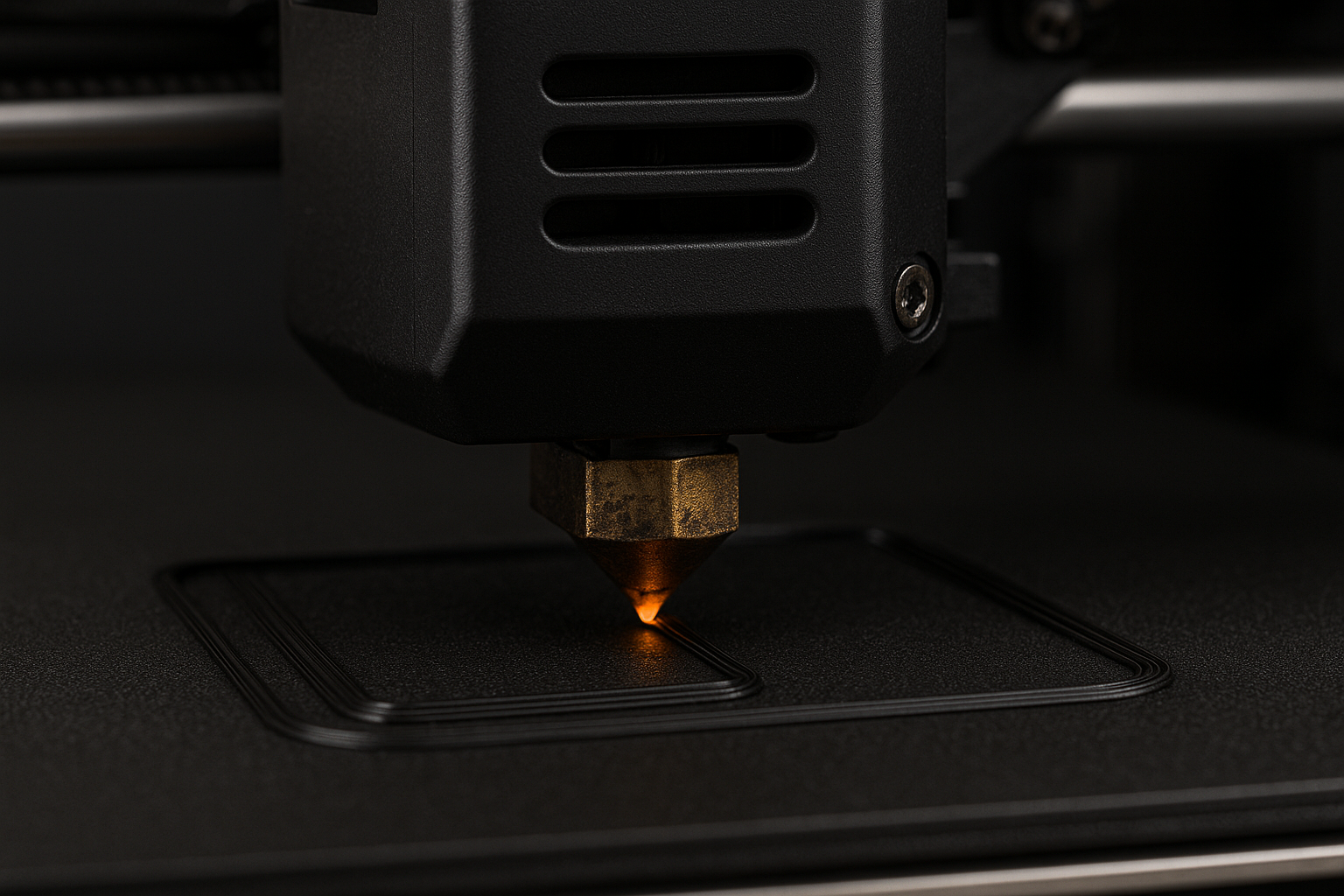 Close-up of a laser engraving machine pressing a design into a black surface.