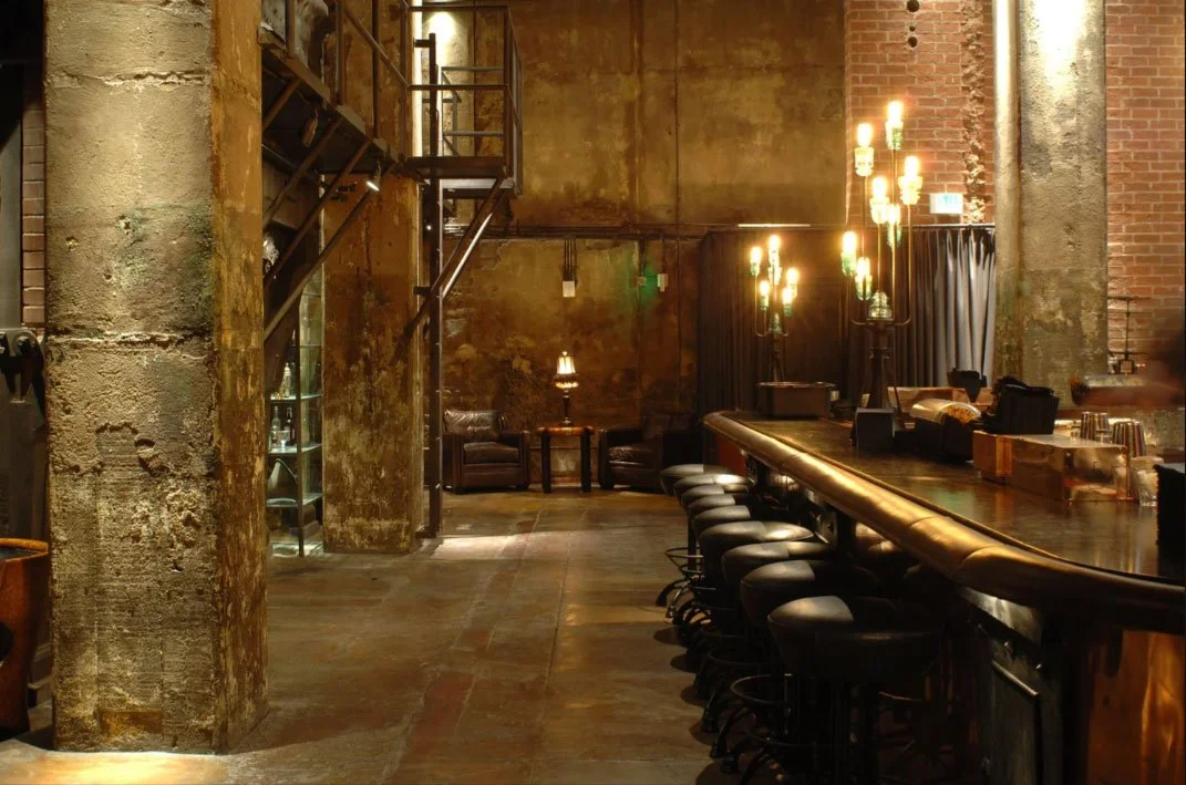 Interior of The Edison featuring preserved industrial architecture, warm lighting, and lounge seating.