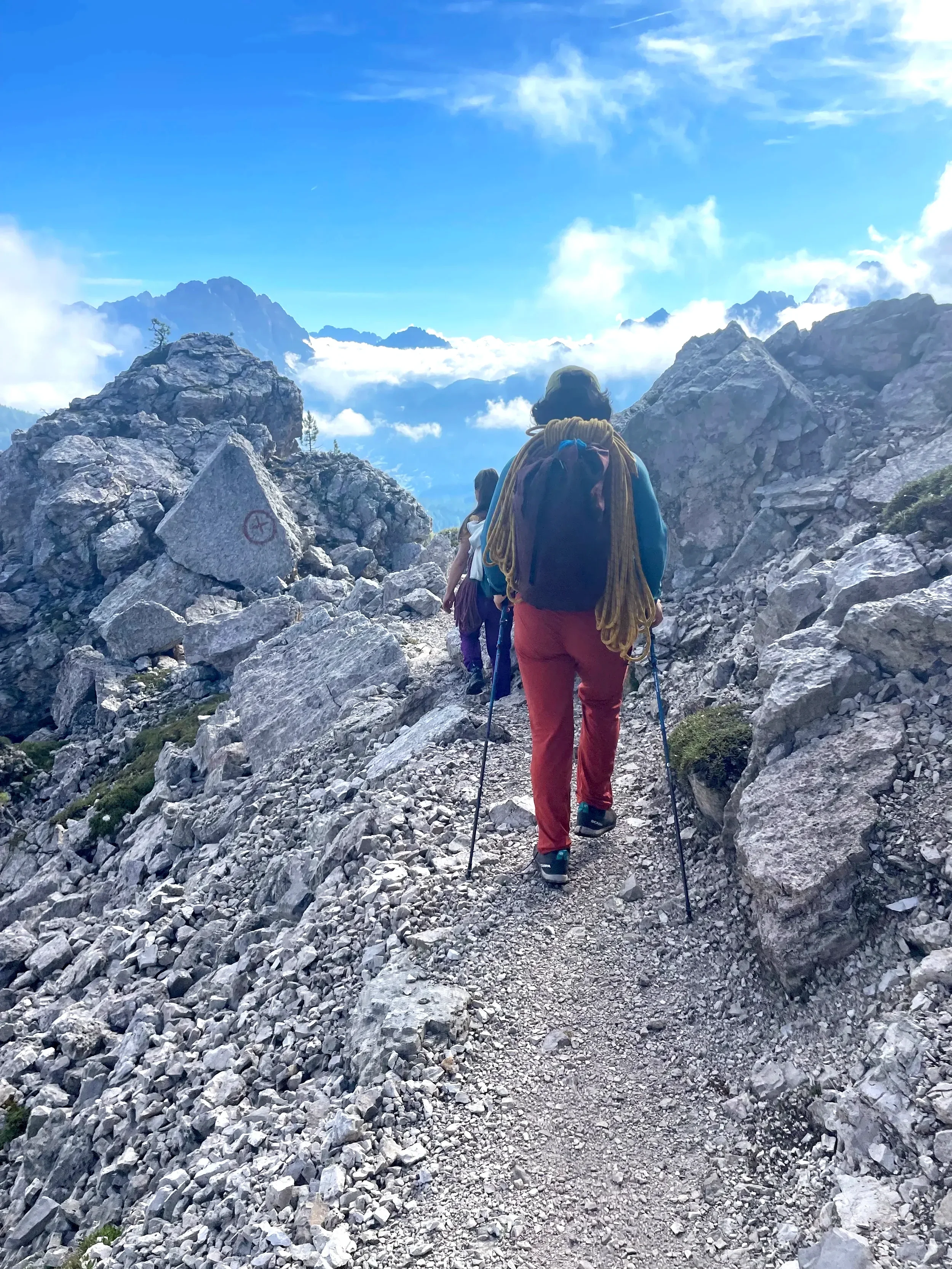 Two climbers walk on a trail in the mountains