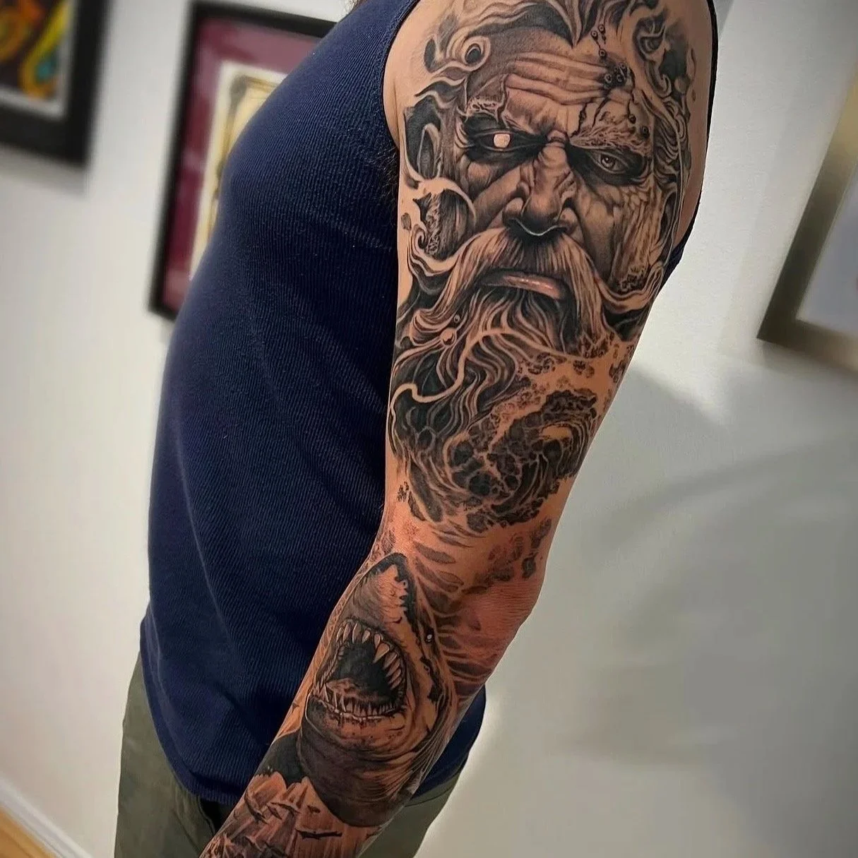 Black and gray tattoo sleeve featuring a fierce old man's face with a long beard and an angry bear's head with open mouth and sharp teeth on a person's arm.