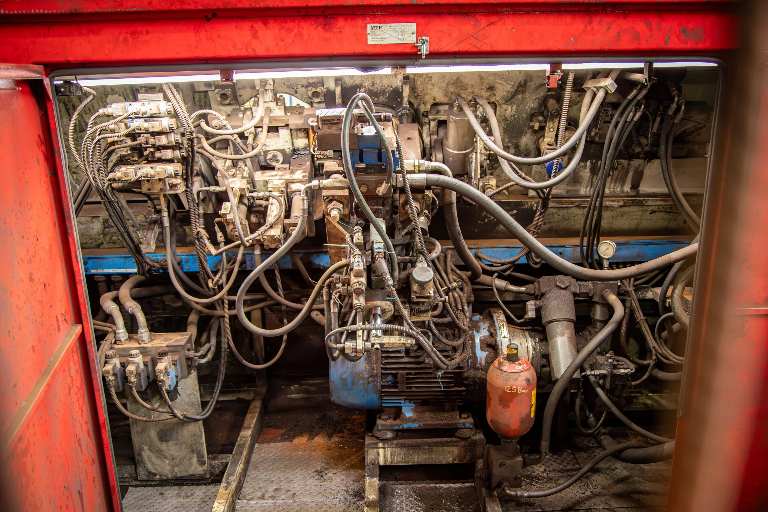 Close-up of Carrabay hydraulic system with pumps, hoses, and valves used in heavy civil construction equipment.