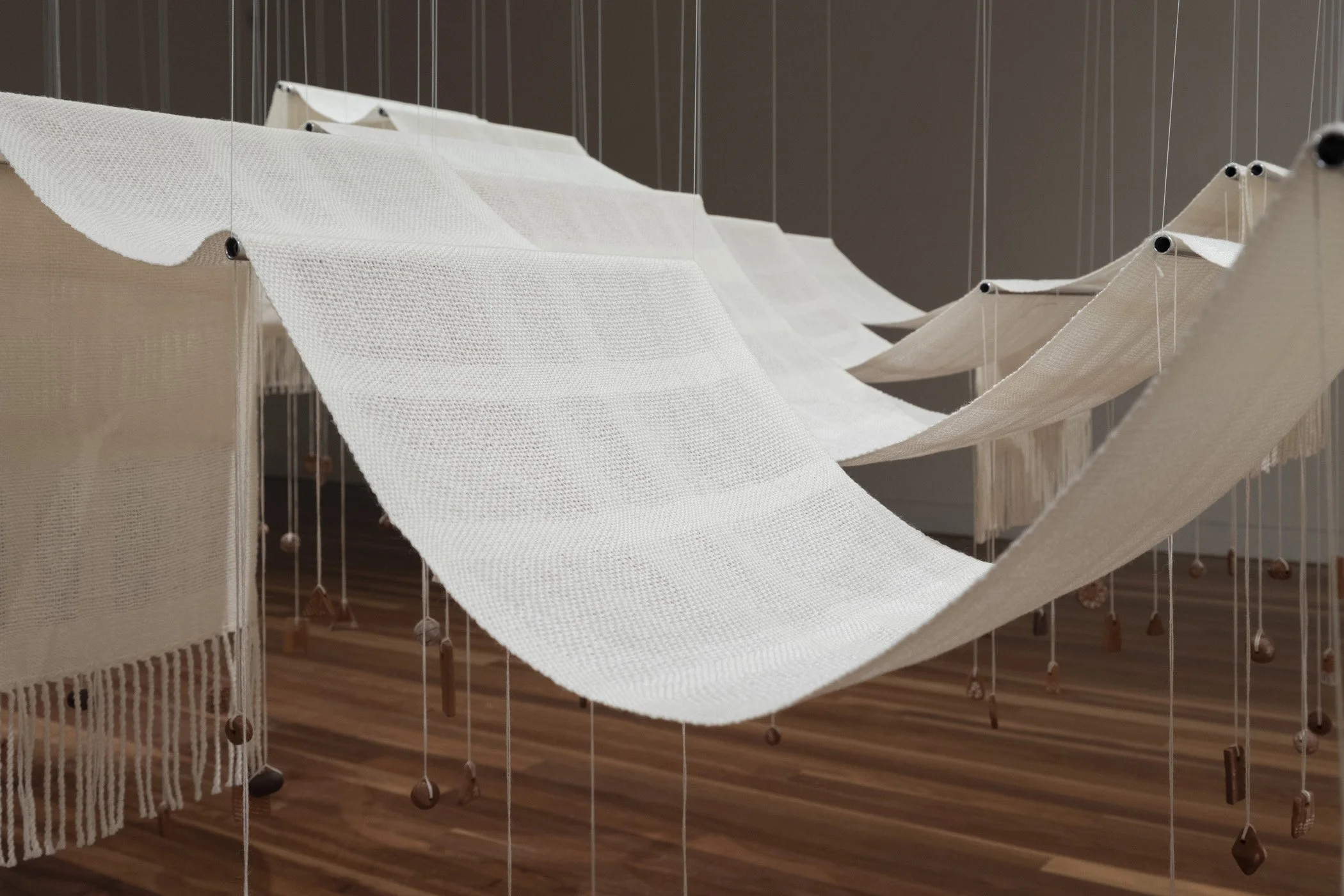 Throwing the fleece. 2026. (Detail).
Woven Aotearoa-grown Corriedale wool, hand-formed papa clay, aluminium tube, stainless steel frame, polyester cord.
360 x 180 x 400 cm.
Photo: Shaun Matthews.
