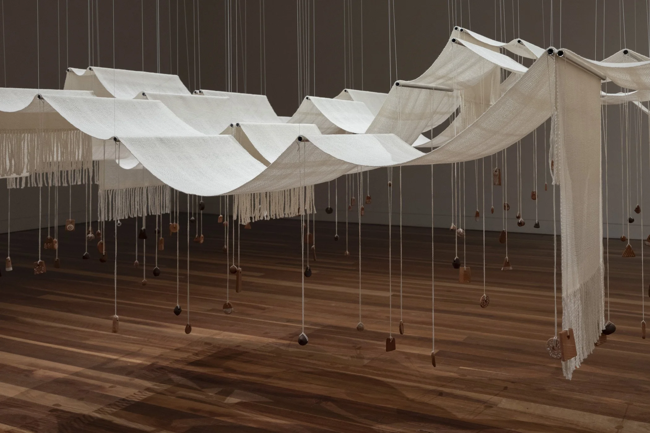 Throwing the fleece. 2026. (Detail).
Woven Aotearoa-grown Corriedale wool, hand-formed papa clay, aluminium tube, stainless steel frame, polyester cord.
360 x 180 x 400 cm.
Photo: Shaun Matthews.