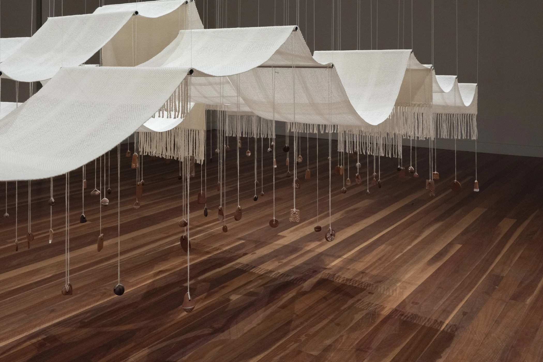 Throwing the fleece. 2026. (Detail).
Woven Aotearoa-grown Corriedale wool, hand-formed papa clay, aluminium tube, stainless steel frame, polyester cord.
360 x 180 x 400 cm.
Photo: Shaun Matthews.