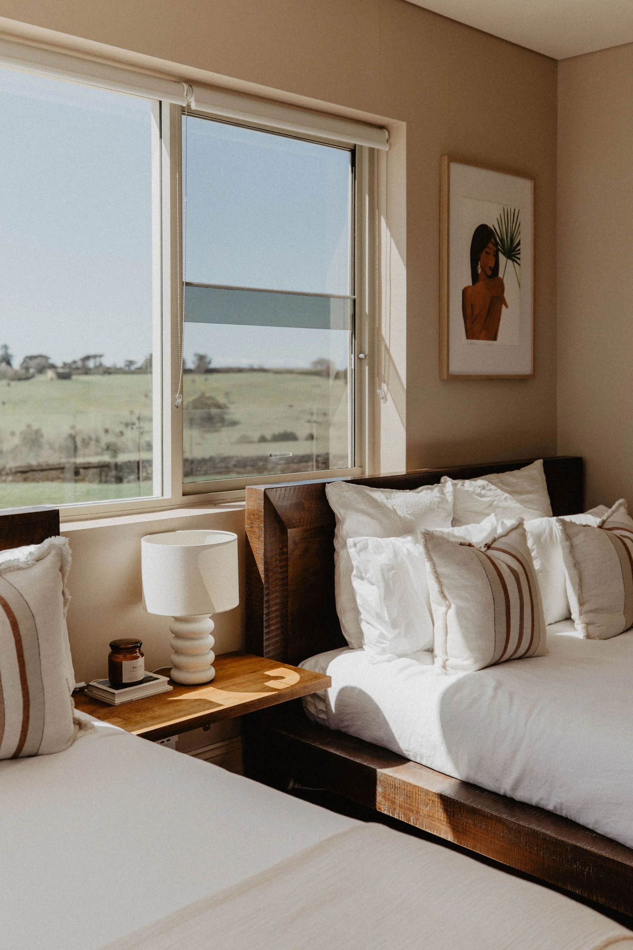 Sunset view over a rural landscape with trees, a distant horizon, and a pool with poolside lounge chairs in the foreground.