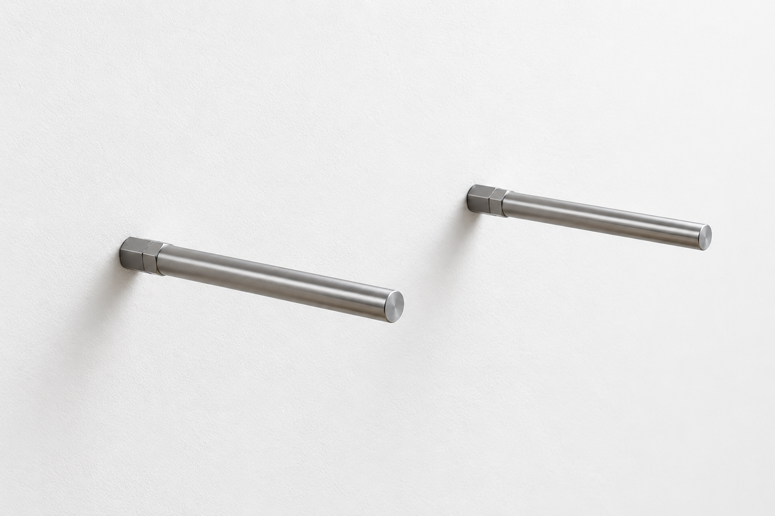Two silver steel mounting pins fixed into a white wall for a floating shelf.