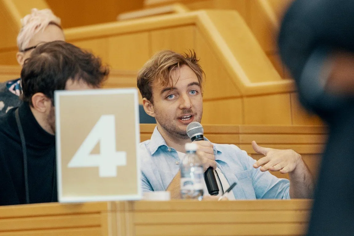 Image showing Philip Barring speaking in a microphone at the Autumn School 2023. The quote on the left of the image belongs to him.