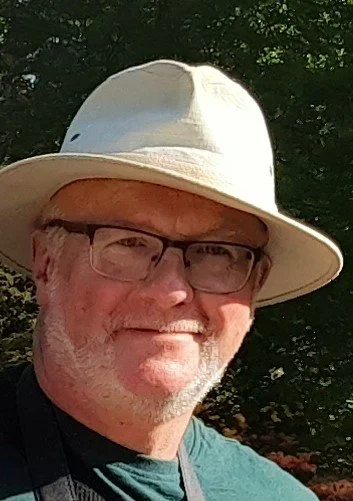 Picture of proprieter of malcolm rumley antiques wearing a white hat