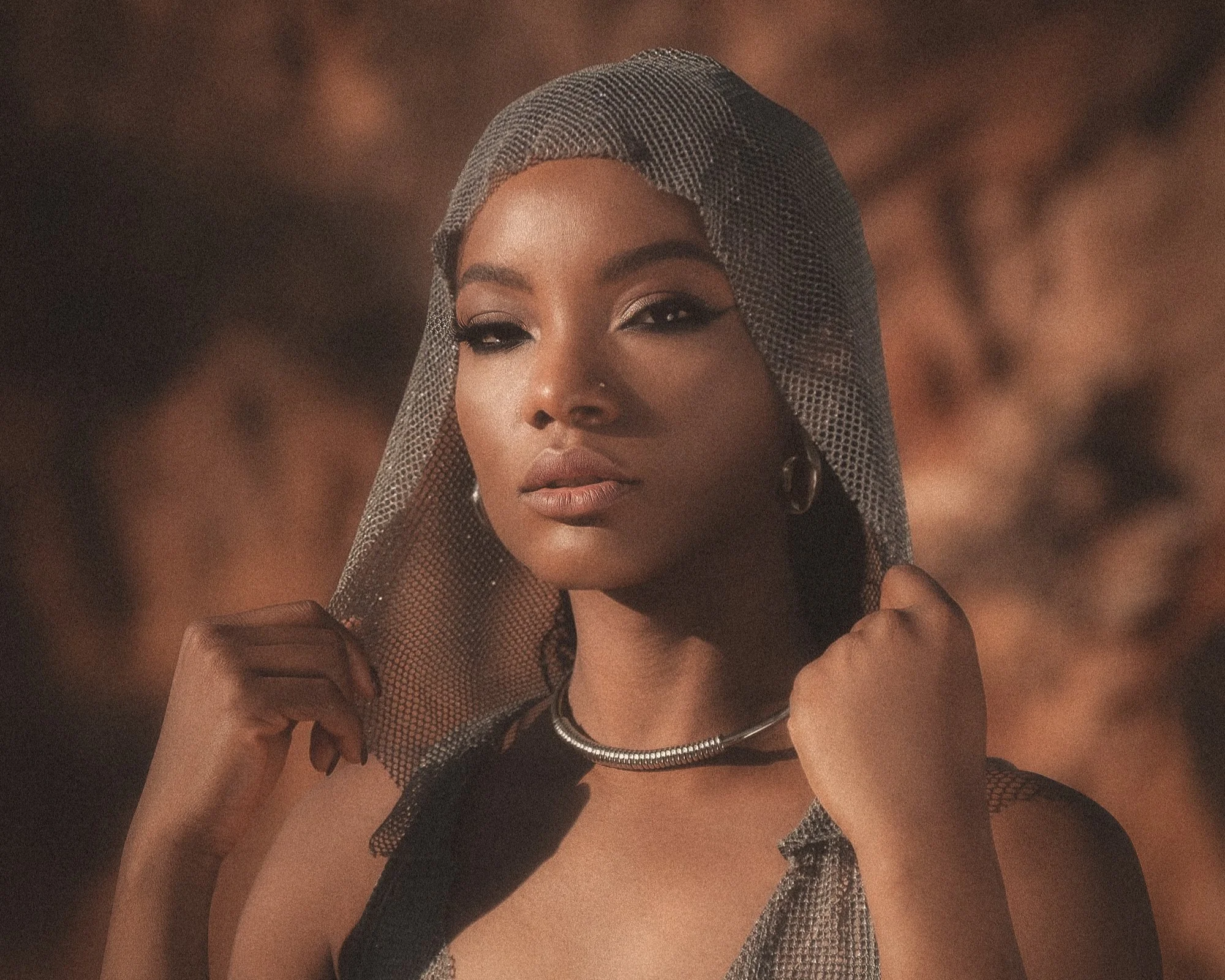 Veiled woman standing in desert light embodying feminine authority, identity reclamation, and post-transformation presence.