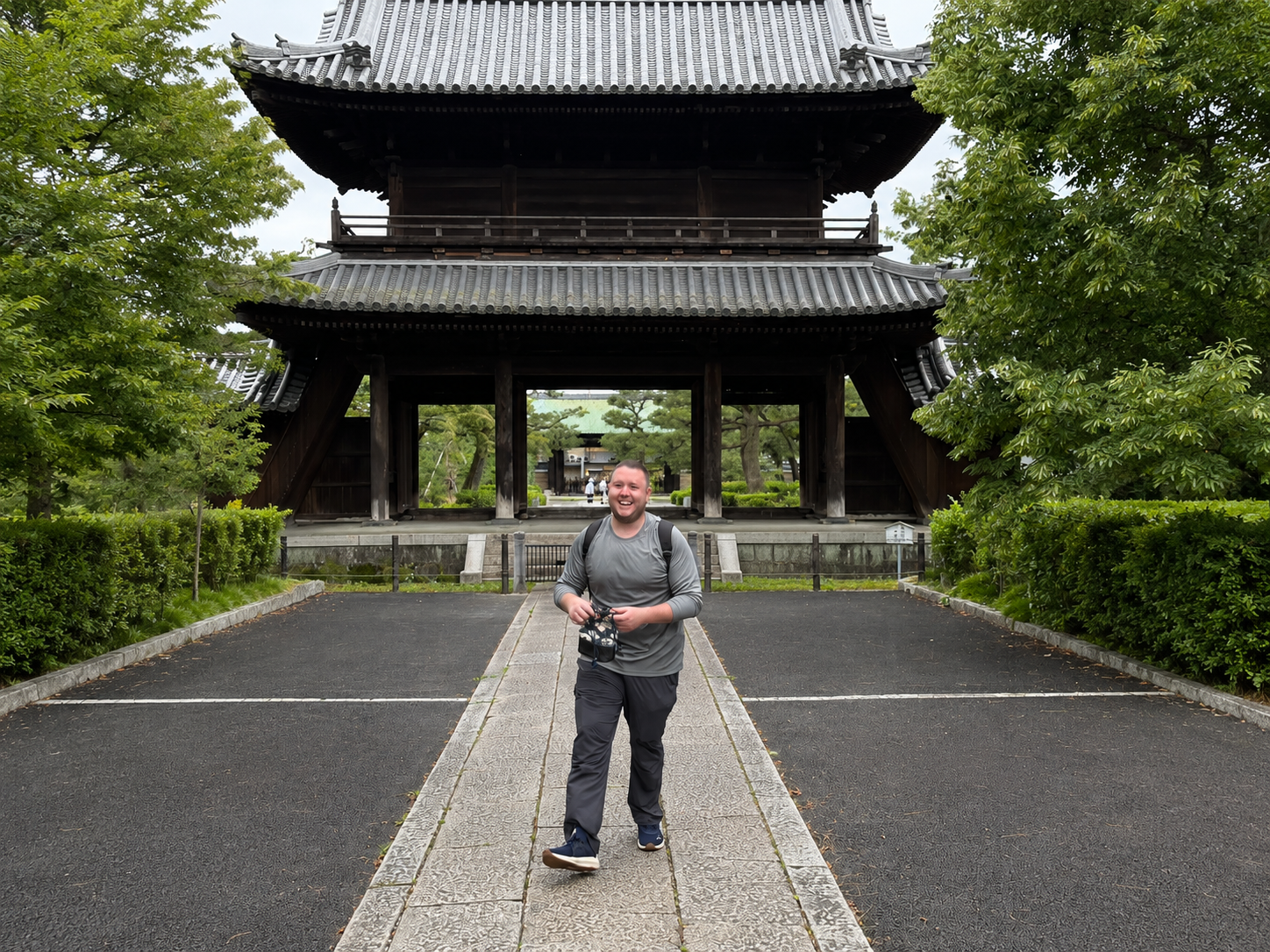 Traveler standing in front of a traditional Japanese shrine in Kyoto, Japan.