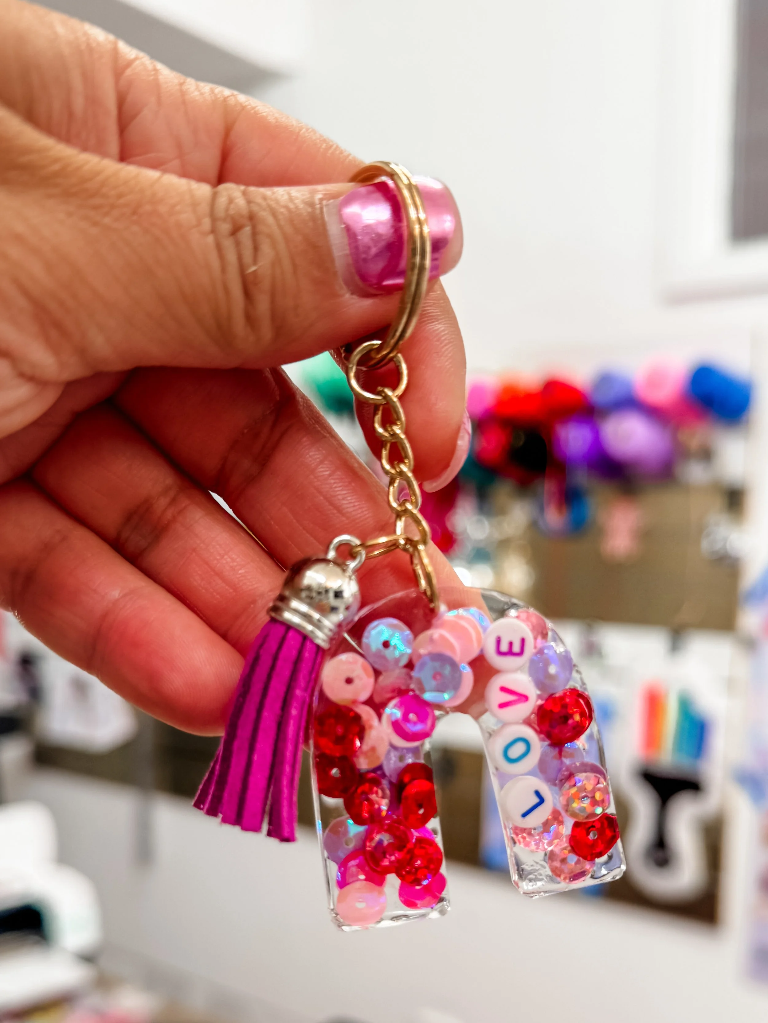 A Man and a woman proudly holding up there rugs made in a tufting workshop, one made a flower rug and the other says Hi