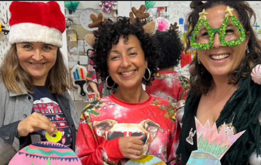 Three women smiling with their crative projects holding proudly
