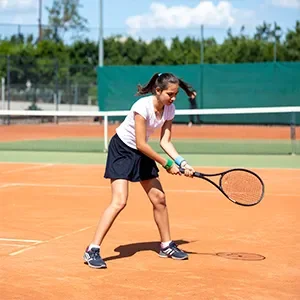 Mädchen spielt Tennis auf einem Tennisplatz.