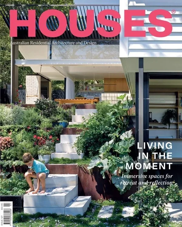 A modern house with a garden featuring a boy playing on stairs, lush greenery, and contemporary architectural design.