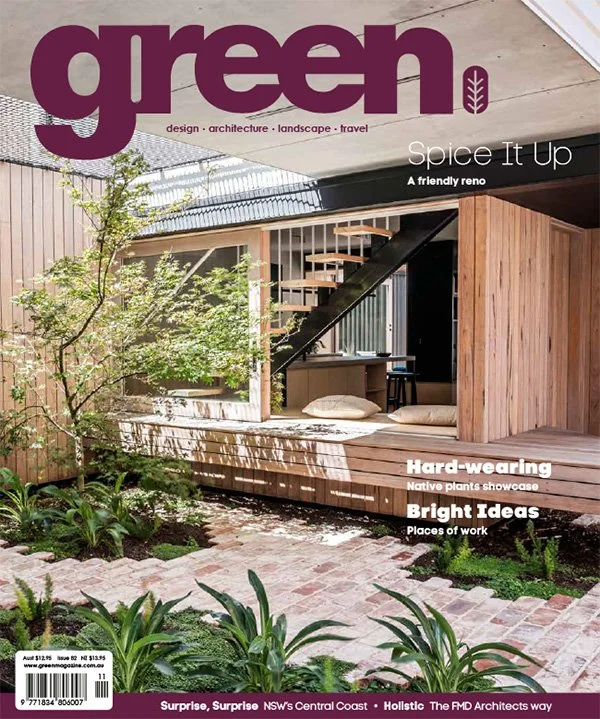 The cover of Green magazine featuring a modern, eco-friendly interior space with wooden accents, plants, and a staircase.