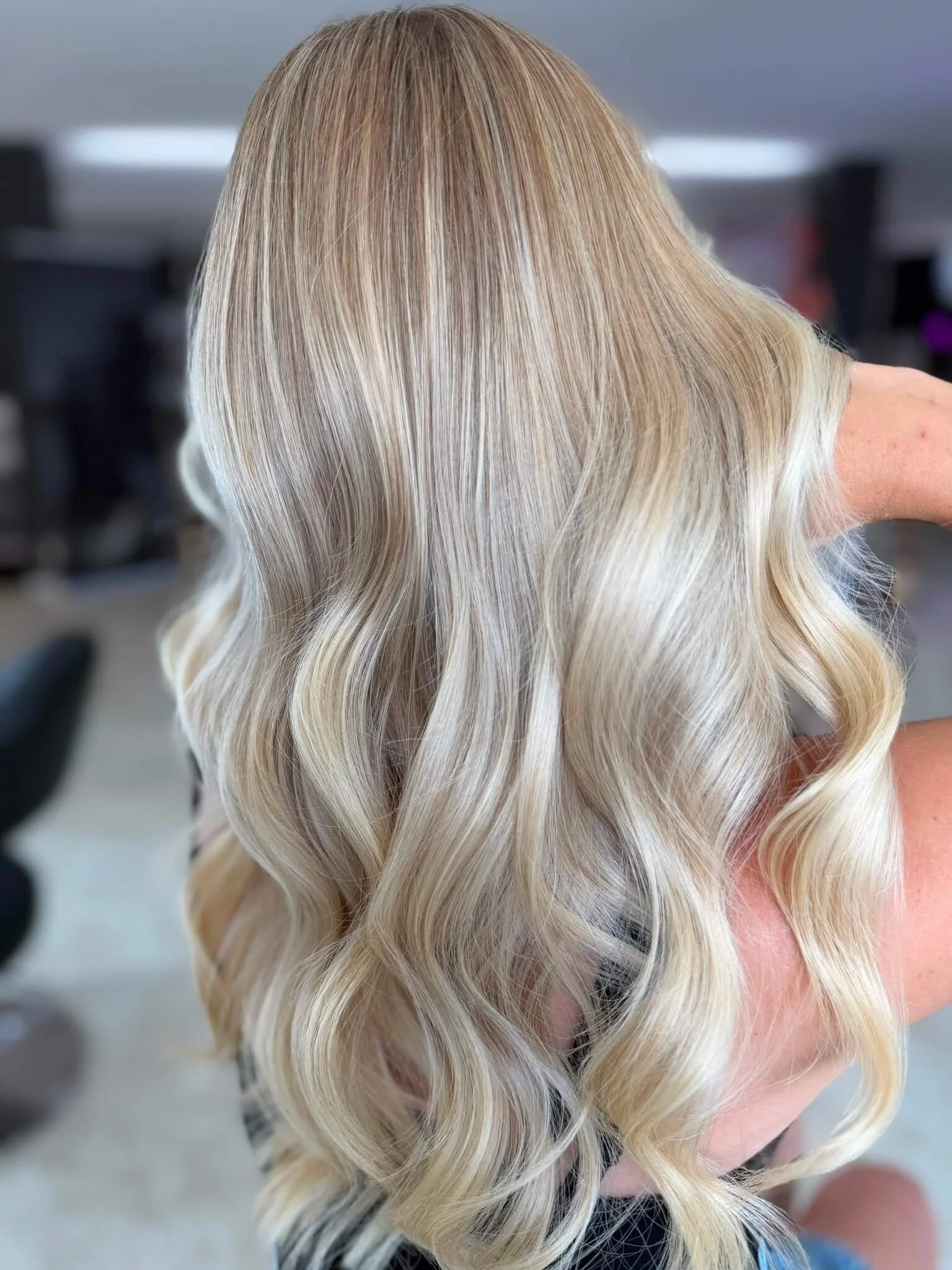 Strahlend blonde, wellengeformte Frisur bei einem Friseurbesuch.