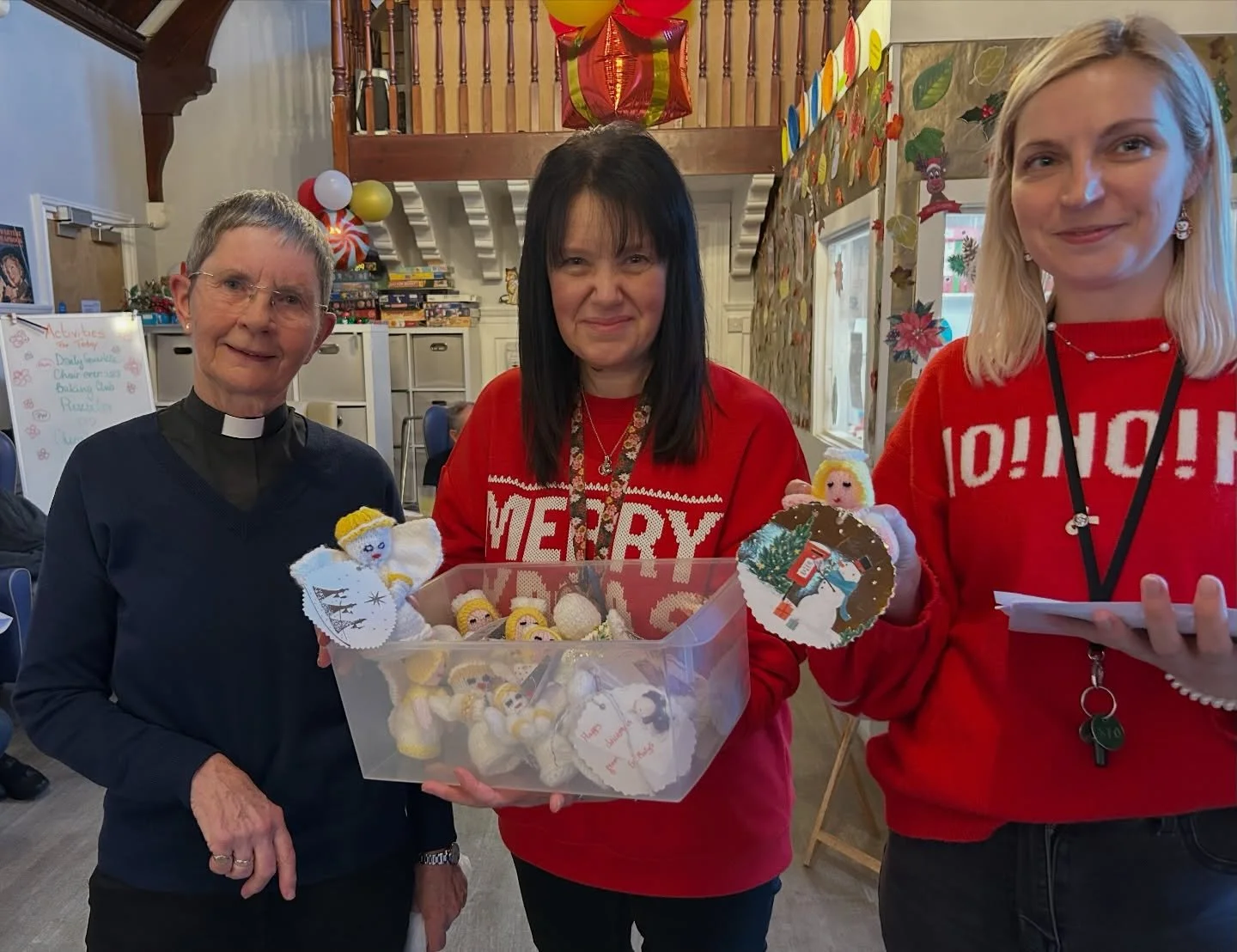 Deacon Hilary is pictured giving the knitted angels to the staff of Manor Hall care home for distribution to their residents. This followed a service of carols led by Deacon Hilary and the St Mary&rsquo;s pastoral team.