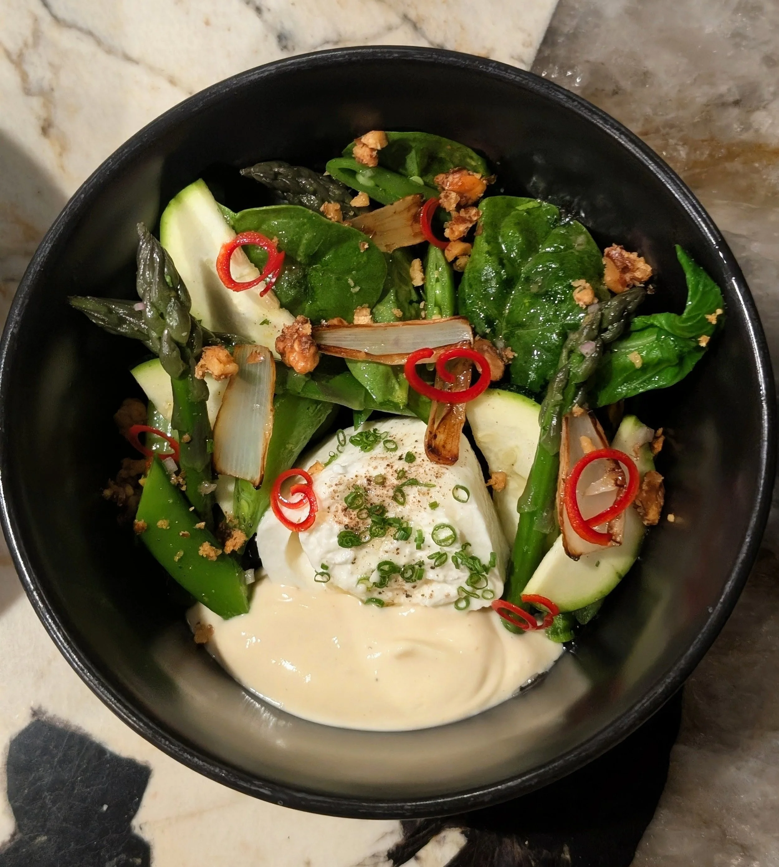 A bowl of Asian soup with vegetables, top view.