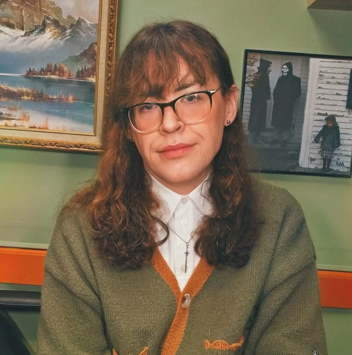 A photo of B.A. Miller as they sit in a tattoo studio room.