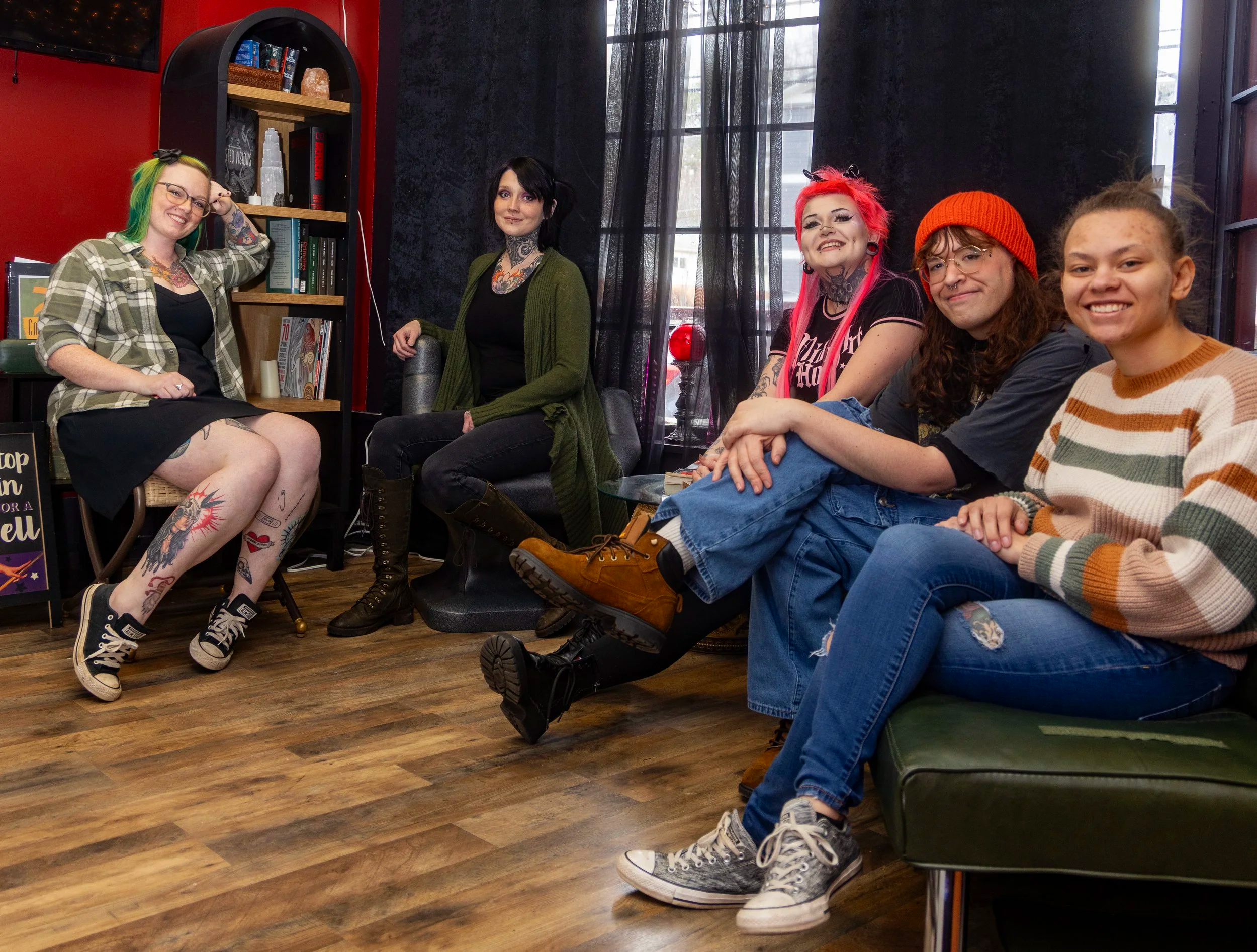 A group photo of the team members at Wicked Vibes Studio sitting on the couch and chairs in the lobby.