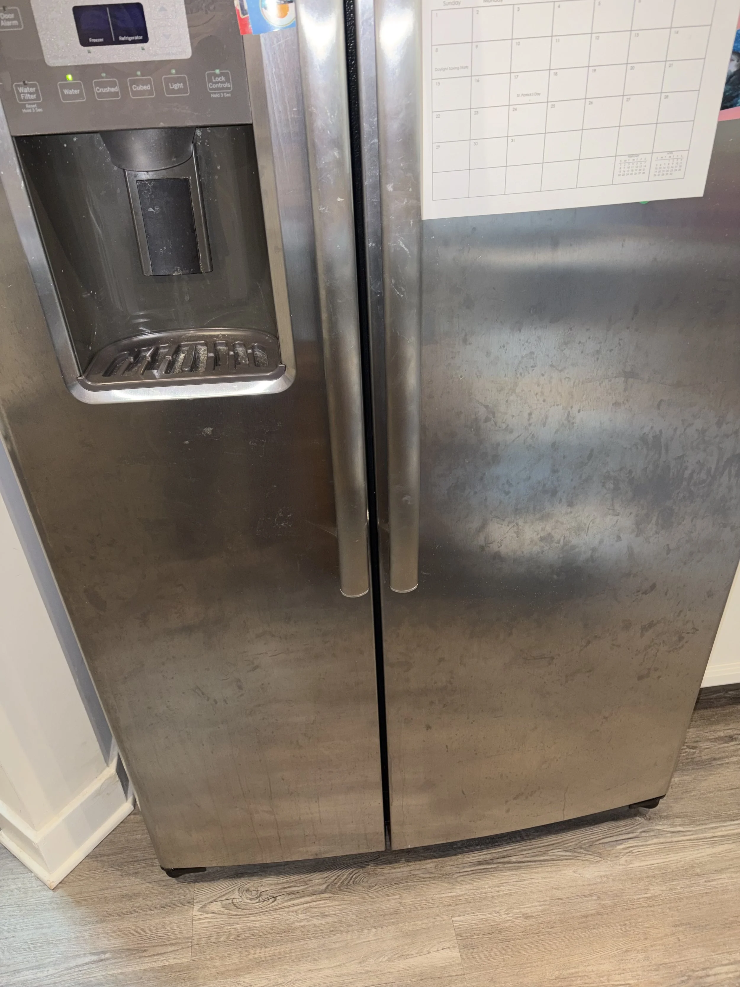Stainless steel side-by-side refrigerator with rust stains