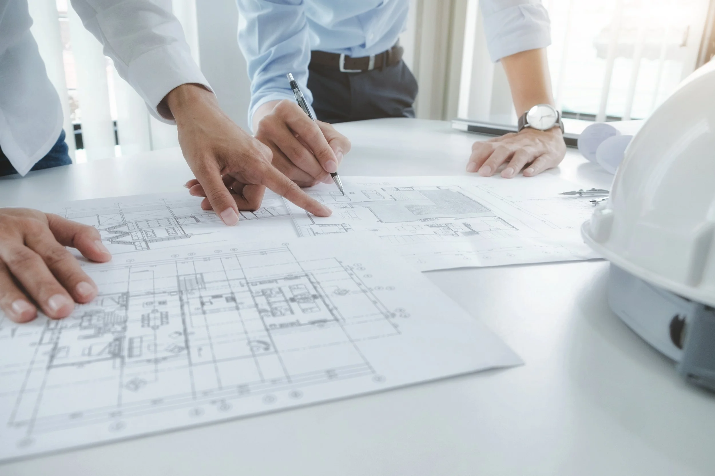 Structural engineers reviewing construction drawings and architectural plans during project design and coordination in North Carolina.