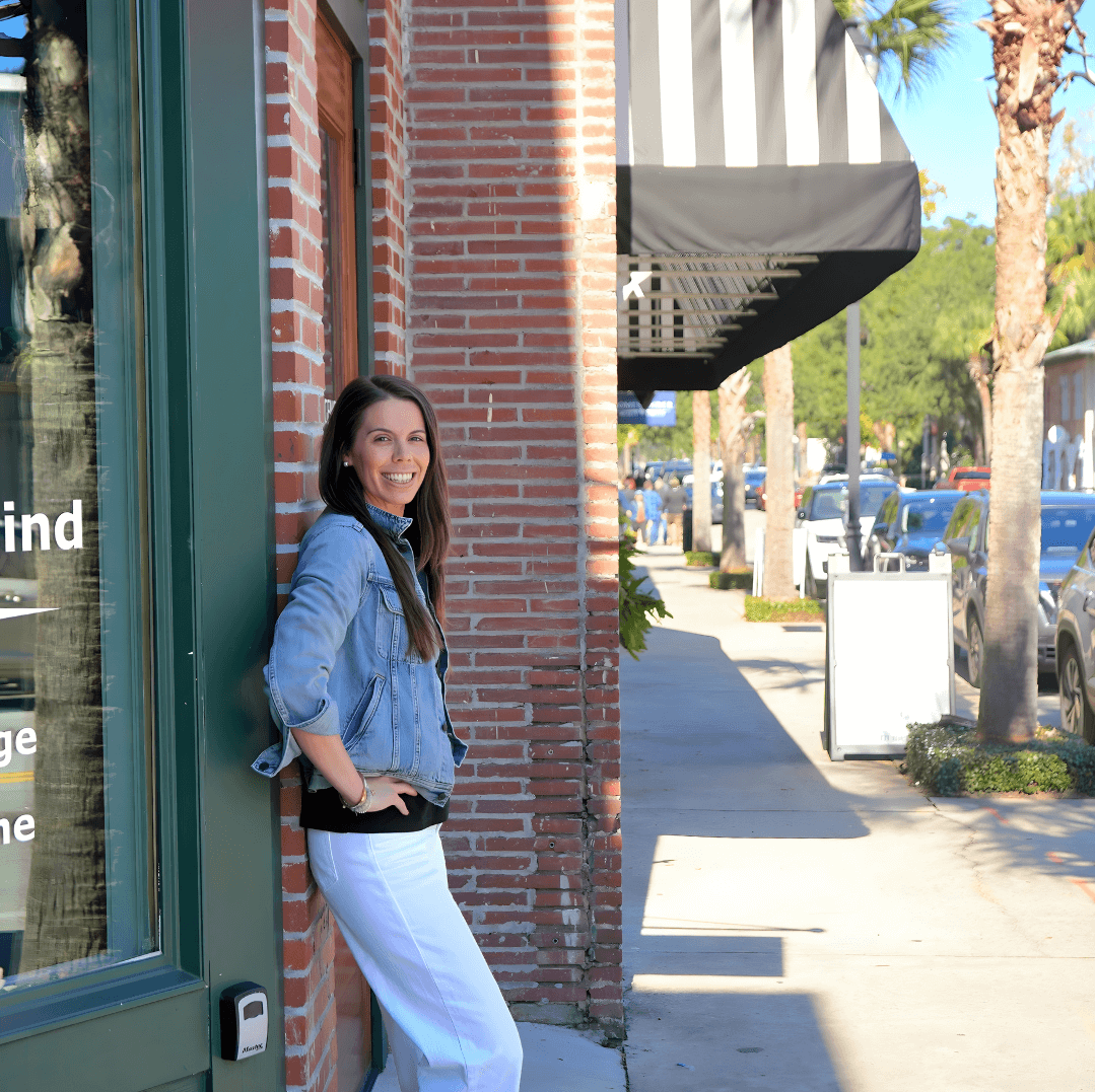 Sally Colleran CPA leaning on a building in Beaufort SC that is owned by one of her retail clients.