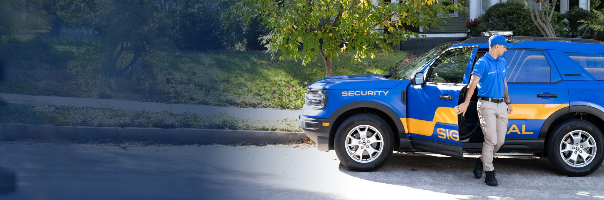 A security officer in a blue uniform standing next to a blue security vehicle.